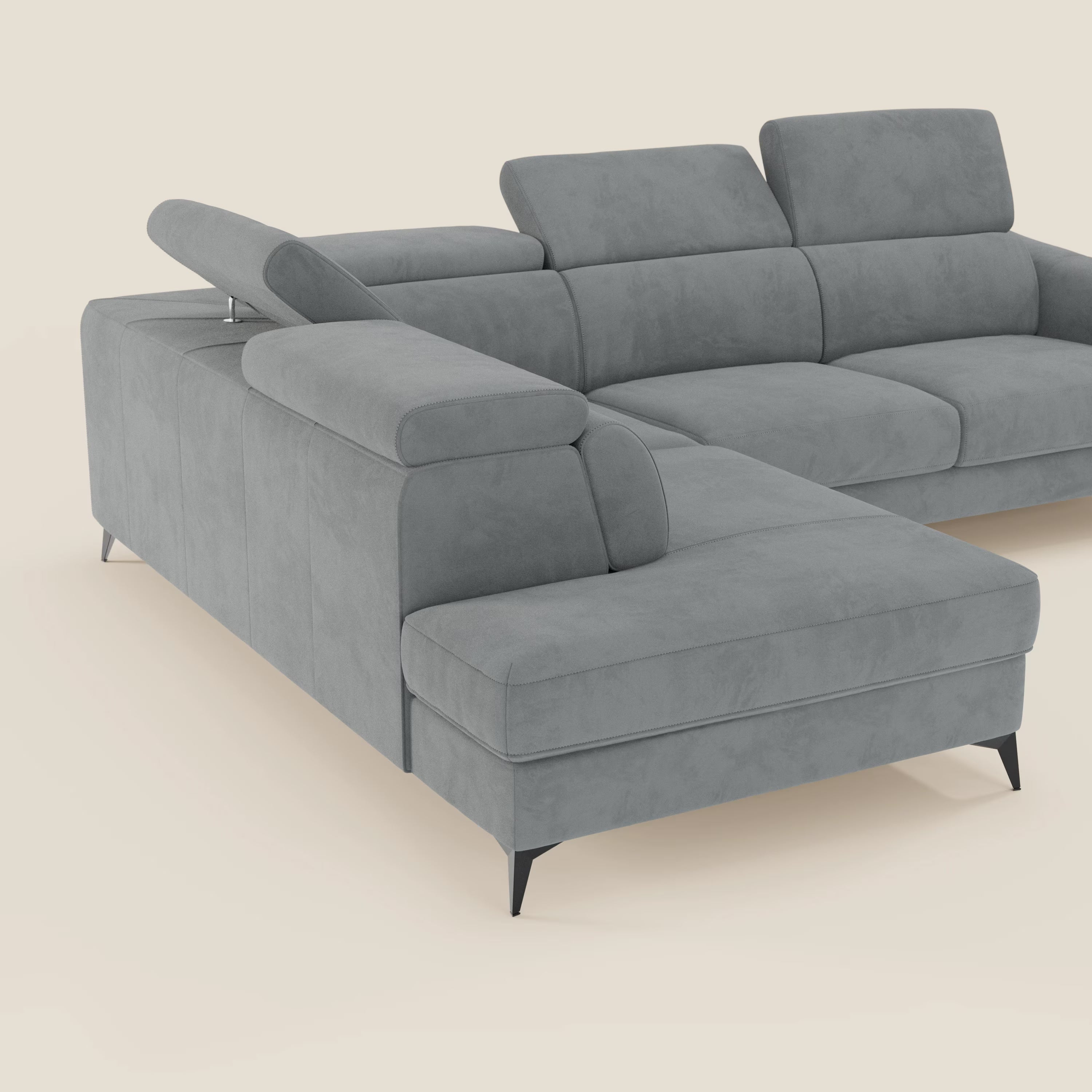 Il divano angolare Arcos di Divani.Store è caratterizzato da alte gambe nere, poggiatesta regolabili e chaise longue sul lato sinistro. Rivestito in microfibra impermeabile T11 grigio chiaro, spicca su uno sfondo crema chiaro.