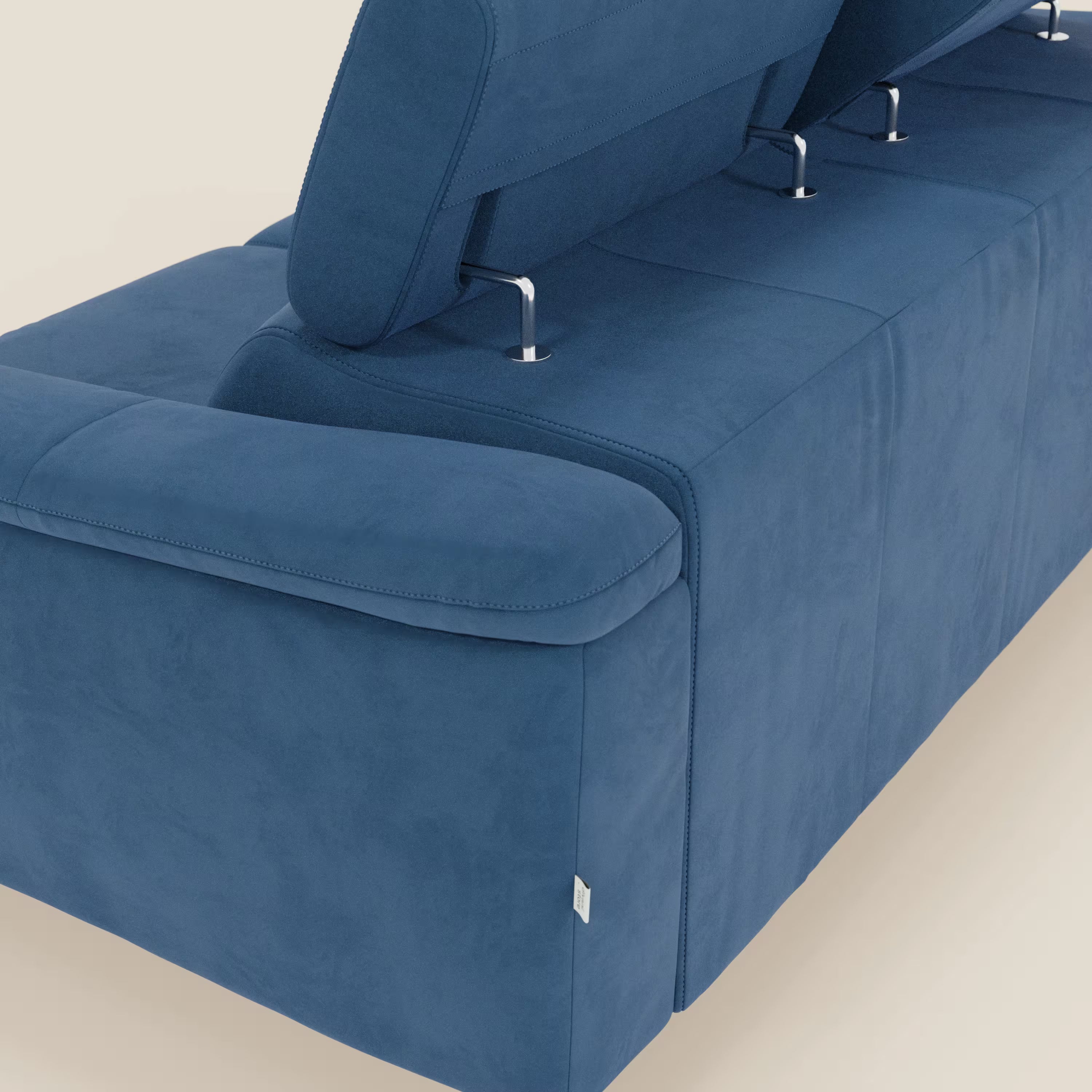 Un primo piano di Arcos Divano 3 posti di Divani.Store mostra la microfibra impermeabile blu T11, le gambe alte, i poggiatesta regolabili e la chaise longue, che accentuano le linee eleganti e il design moderno su una superficie chiara.
