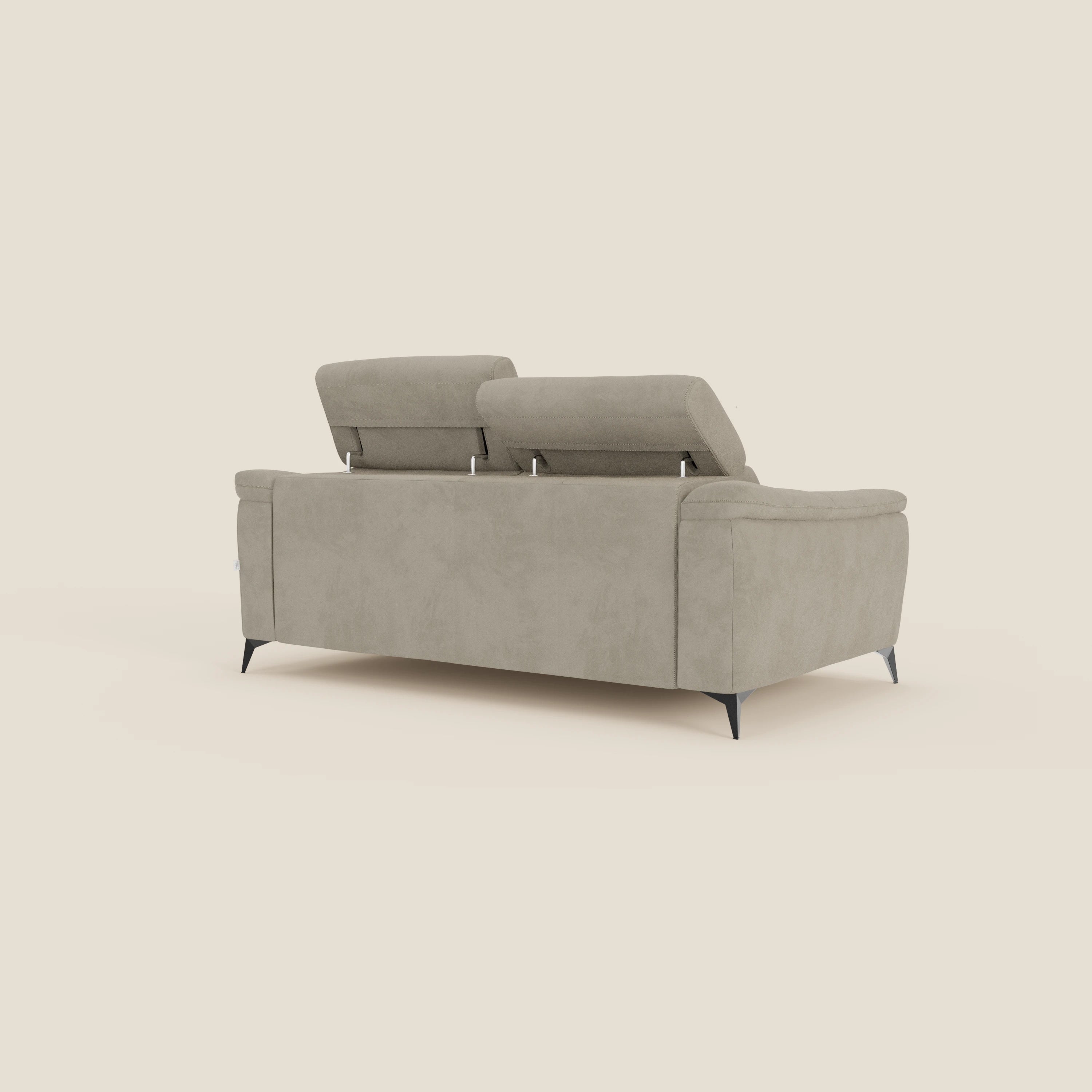 Arcos Divano 3 posti di Divani.Store è caratterizzato da alte gambe nere, due poggiatesta reclinabili e microfibra tortora T11 resistente all'acqua. Il design minimalista e la tonalità beige chiaro spiccano su uno sfondo color crema.