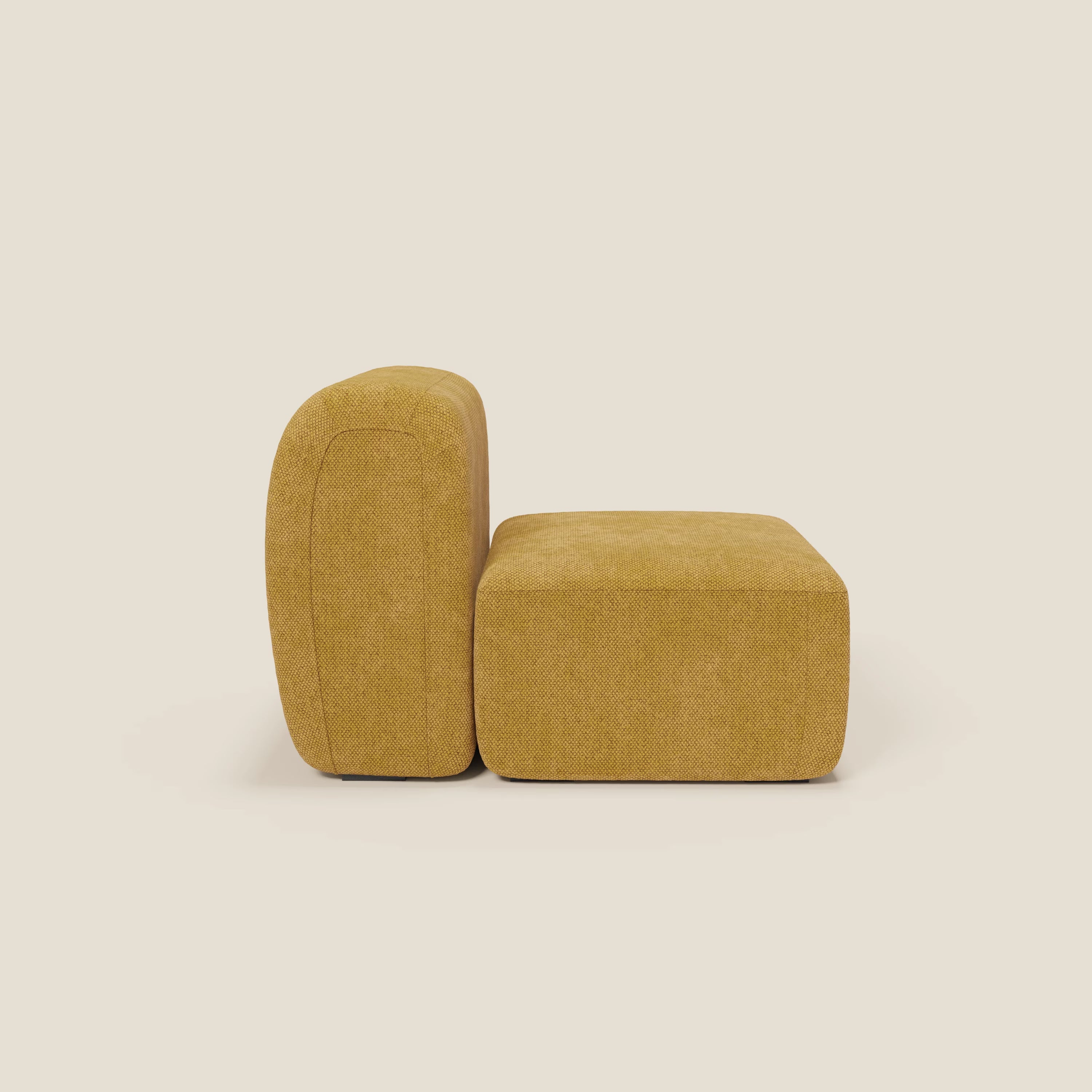 La sedia BonBon modulo centrale 70 cm - Grande Fratello edition giallo di Divani.Store è una moderna sedia senza braccioli di colore giallo senape, con seduta spessa e schienale arrotondato in tessuto strutturato, presentata di lato su uno sfondo bianco sporco.