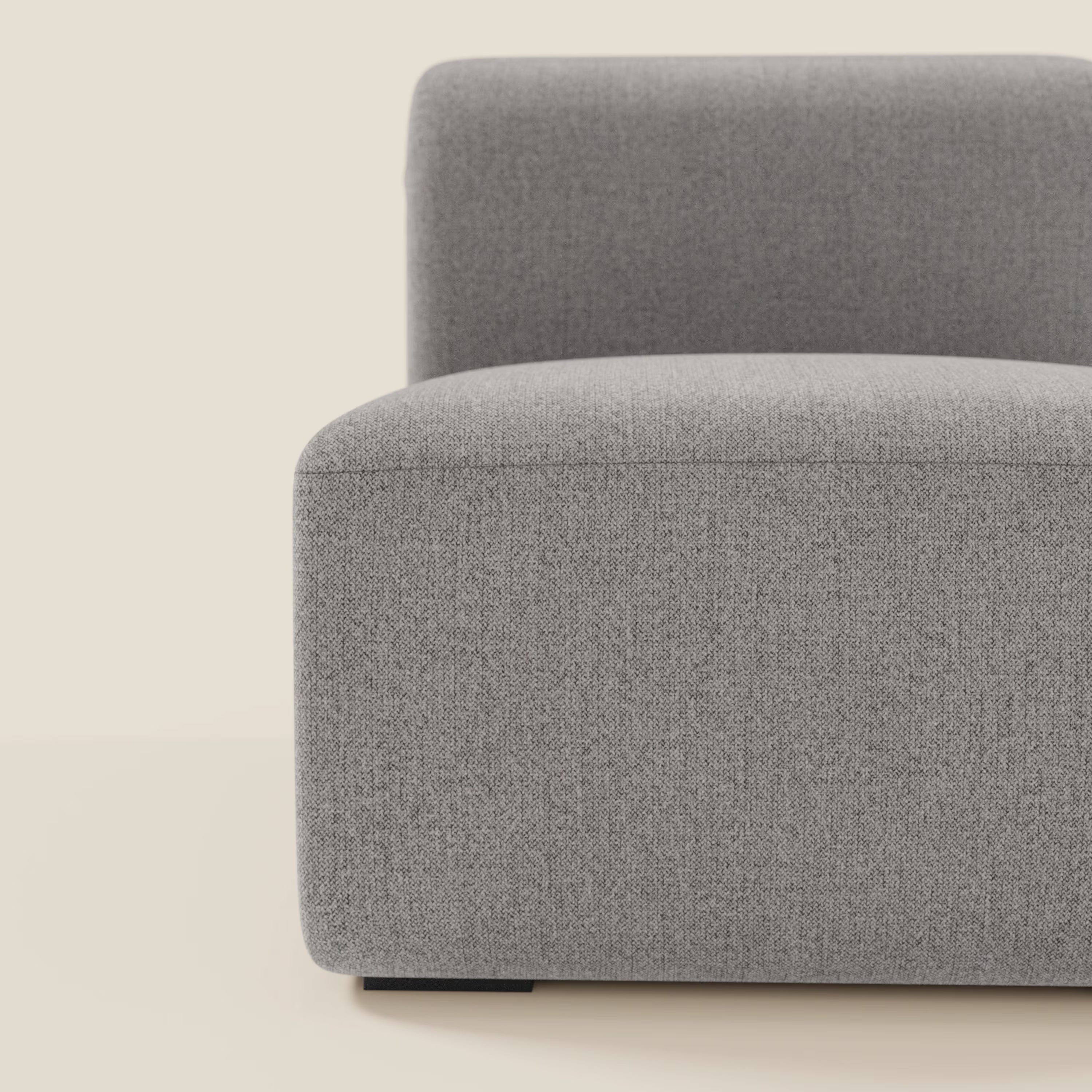 Primo piano di BonBon modulo centrale 70 cm di Divani.Store in tessuto smacchiabile T23 grigio, caratterizzato da linee pulite e bordi arrotondati. L'immagine mostra solo il lato sinistro e la seduta, con sfondo beige.