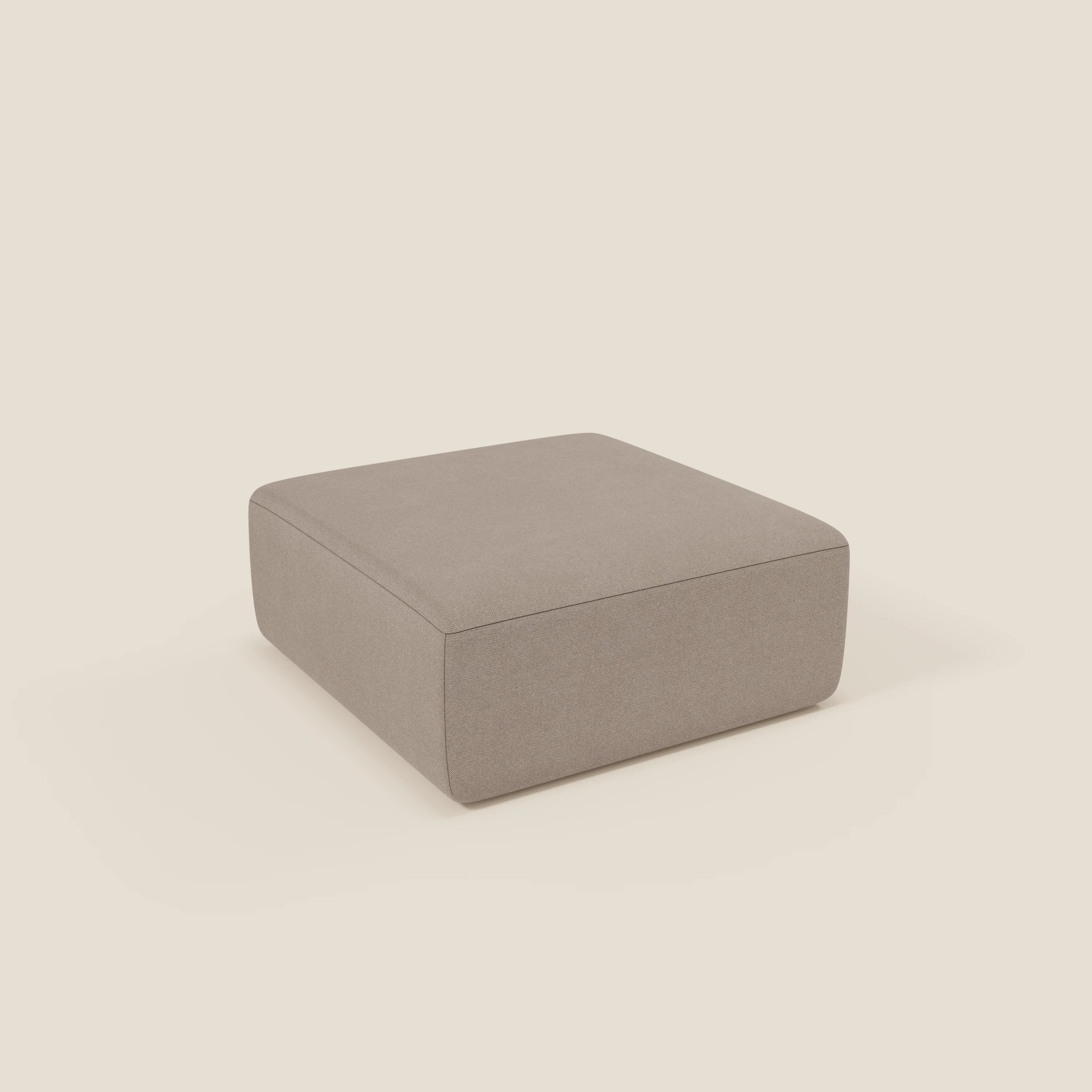 Il pouf divano modulare BonBon di Divani.Store in tessuto smacchiabile T23 tortora è un pouf quadrato senza gambe con lati lisci, top piatto e linee pulite e moderne, presentato su uno sfondo chiaro senza cuciture.