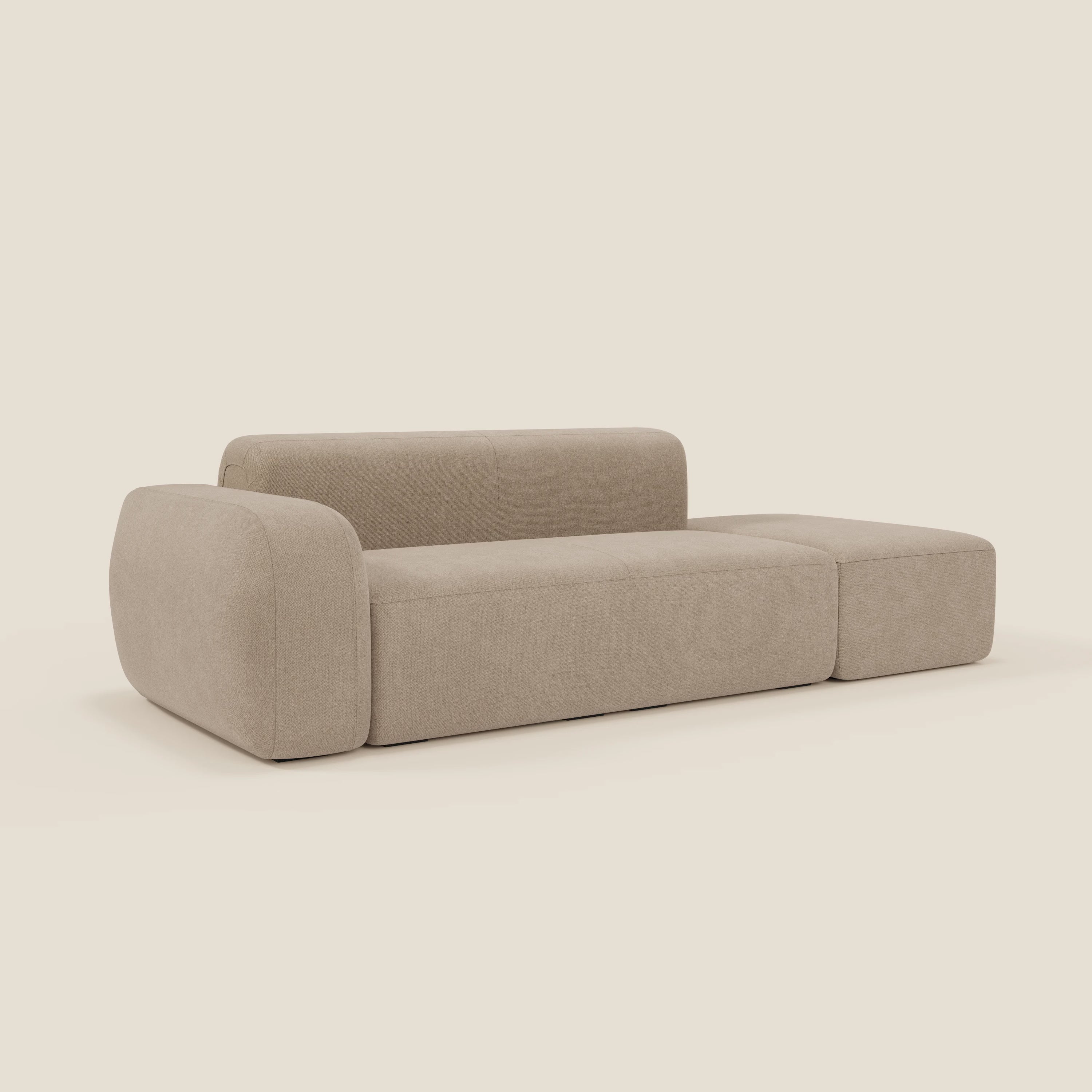 Il BonBon Divano componibile di Divani.Store in tessuto antimacchia T23 beige ha un design moderno e morbido con schienale basso, braccioli ampi e arrotondati, linee pulite e un pouf terminale abbinato per una maggiore versatilità.