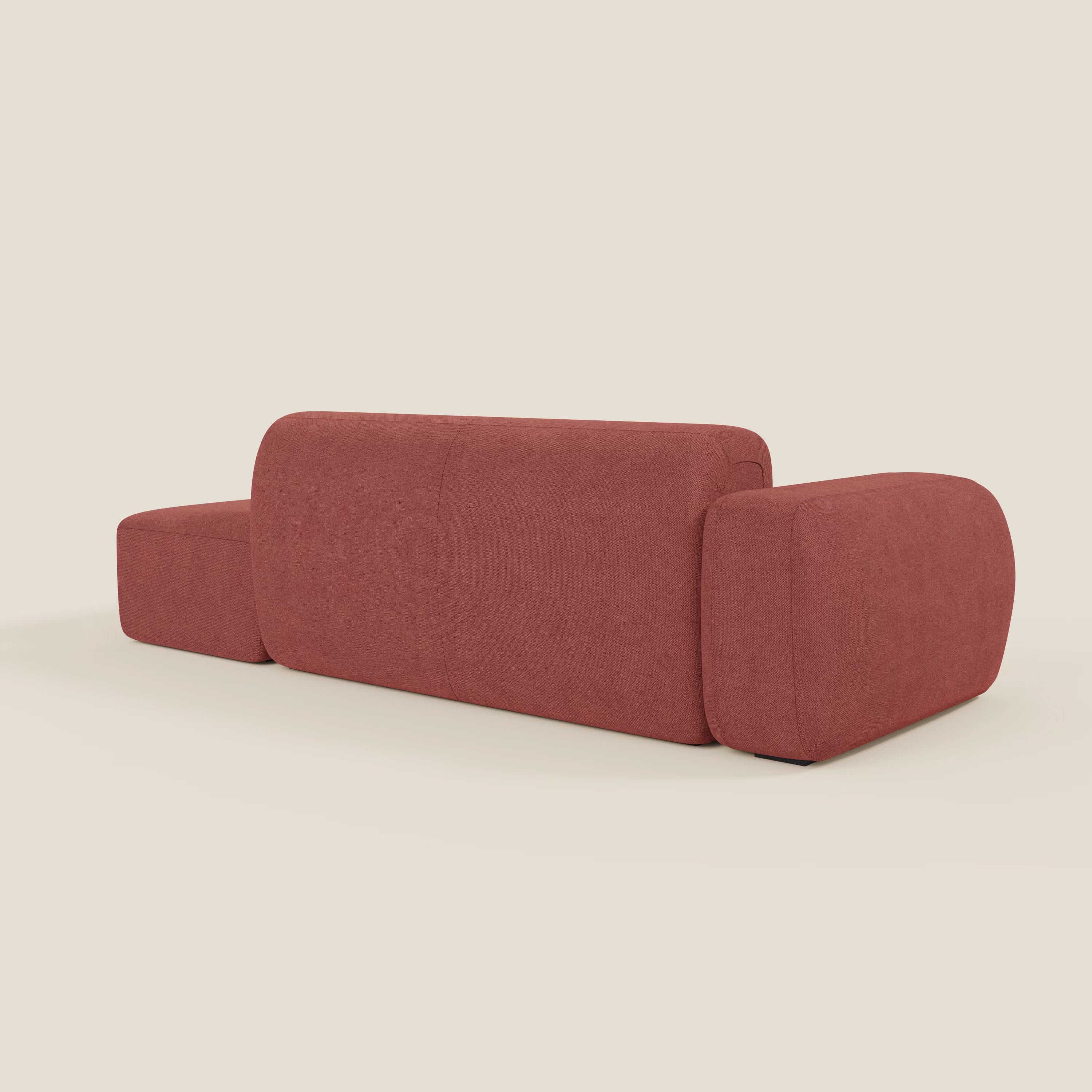 Il BonBon Divano componibile di Divani.Store in T23 rosso ciliegia è caratterizzato da bordi arrotondati, cuscini morbidi e ampi braccioli. Visto da dietro, il suo rivestimento senza cuciture e il suo stile minimalista spiccano su uno sfondo beige semplice.