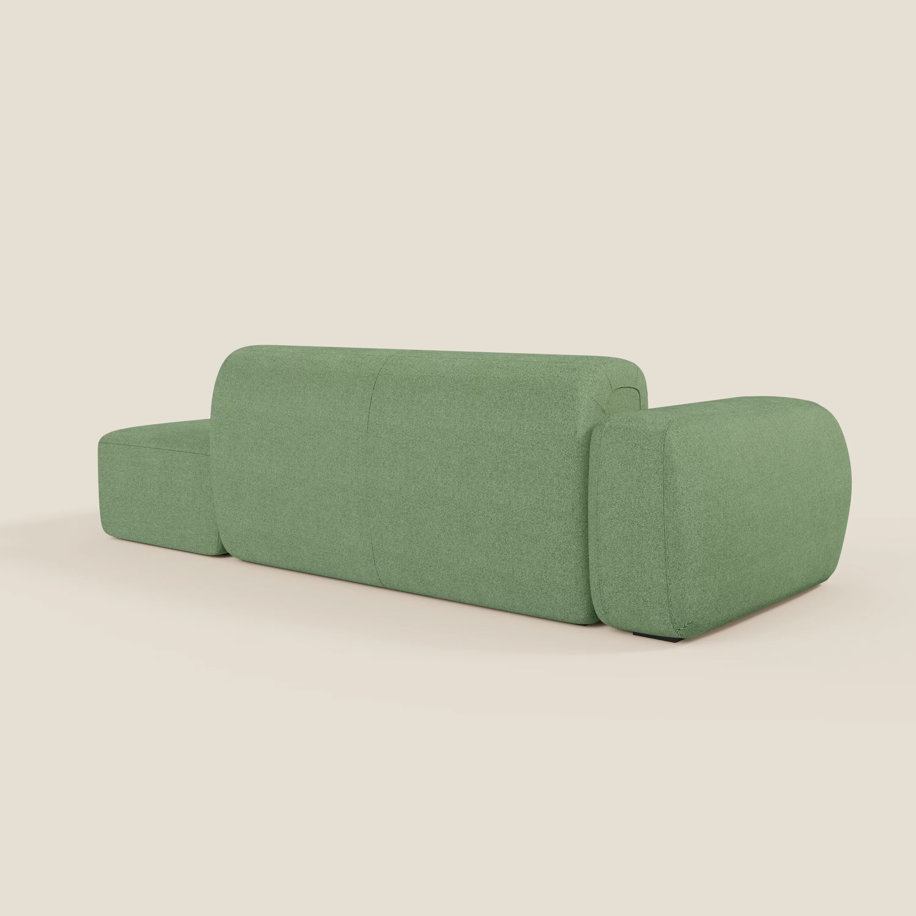 Il divano componibile BonBon di Divani.Store è caratterizzato da linee morbide e arrotondate e da un look minimalista in tessuto antimacchia T23 menta, con schienale basso, ampi braccioli e pouf terminale su uno sfondo bianco sporco.