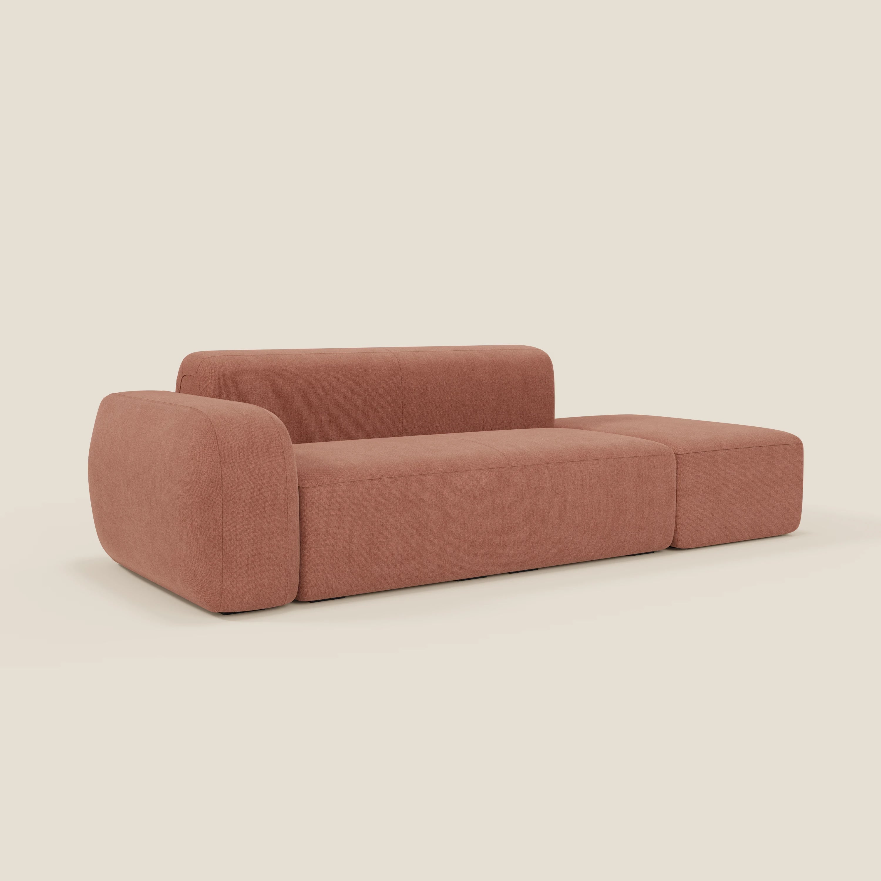 Il divano componibile BonBon di Divani.Store è caratterizzato da un design minimalista in tessuto smacchiabile T23 pesca con bordi arrotondati, seduta e schienale larghi e bassi e gambe nascoste per un look elegante su uno sfondo beige chiaro.