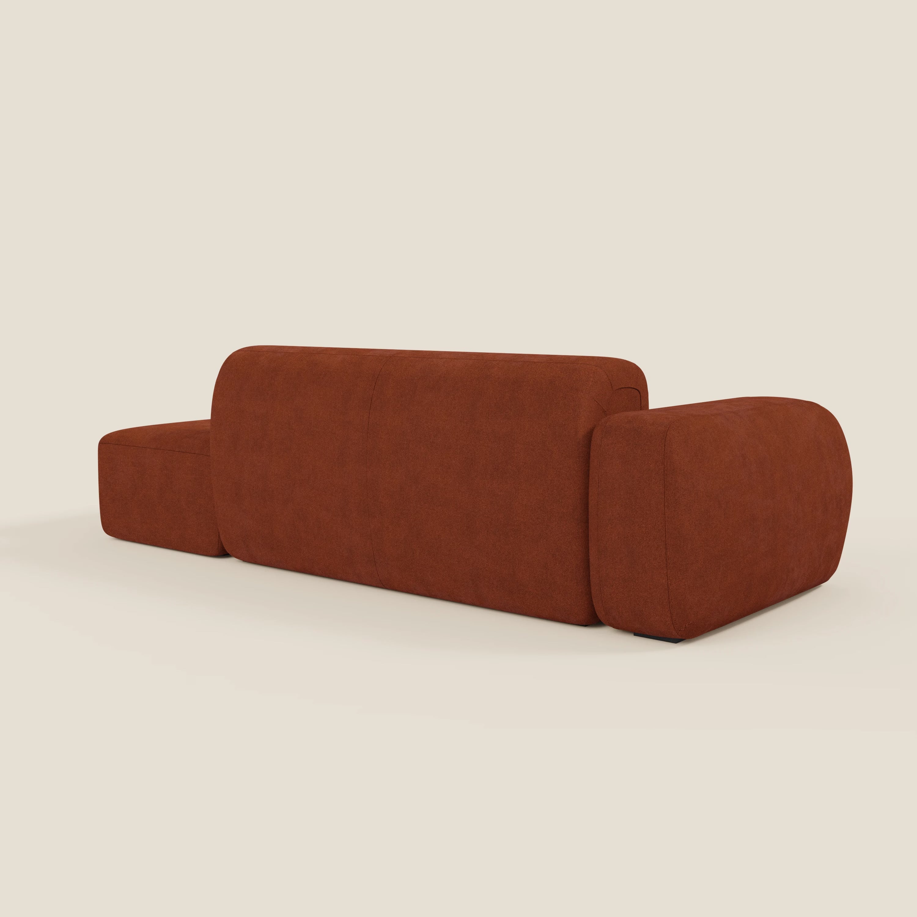 Il BonBon Divano componibile di Divani.Store, in tessuto smacchiabile T23 ruggine, è caratterizzato da uno schienale basso, braccioli oversize e bordi arrotondati e lisci, su sfondo bianco sporco con pouf terminale incluso.