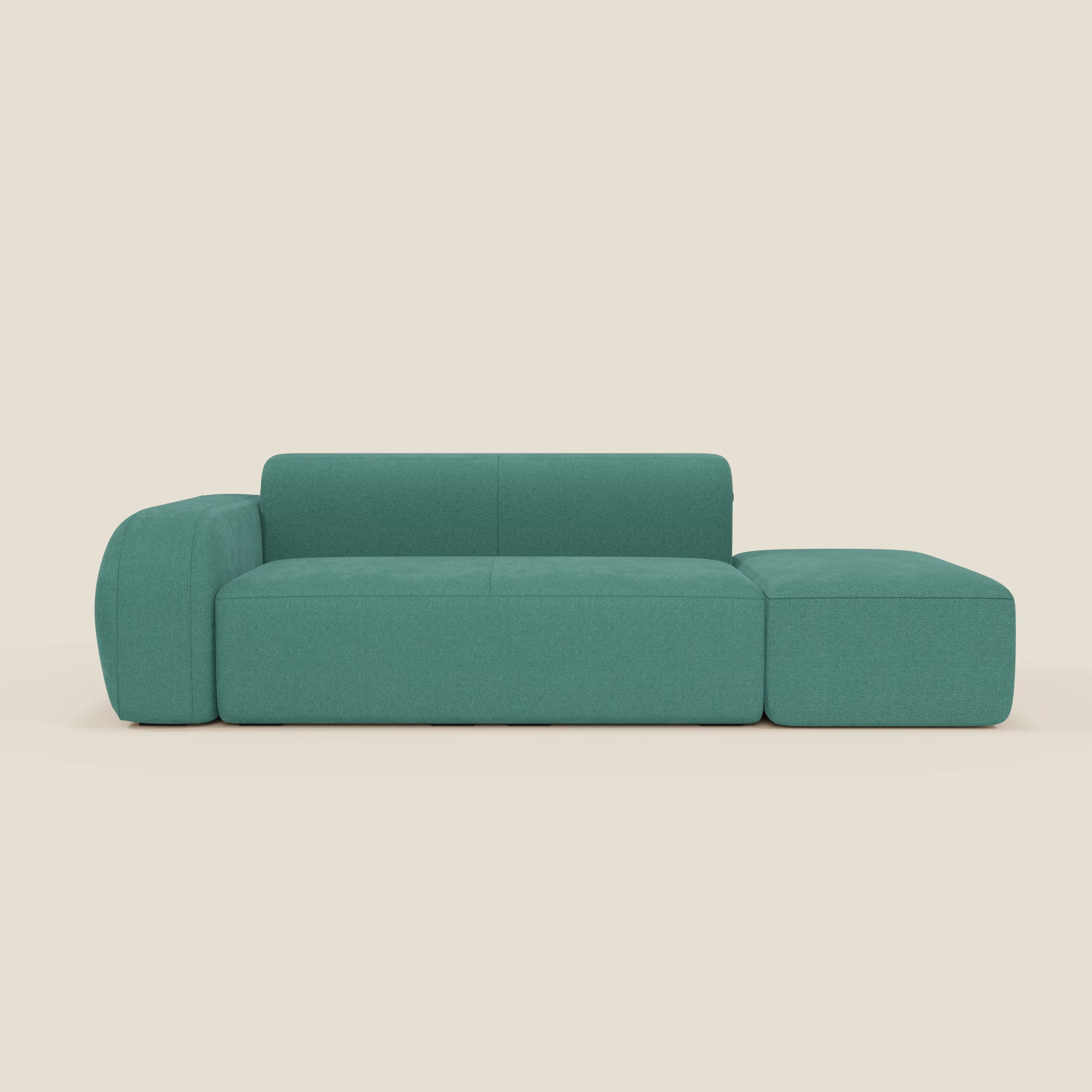 Il BonBon Divano componibile di Divani.Store, in smacchiabile T23 verde acqua, è caratterizzato da linee pulite, schienale basso, ampio bracciolo sinistro e pouf destro annesso, su uno sfondo beige chiaro.