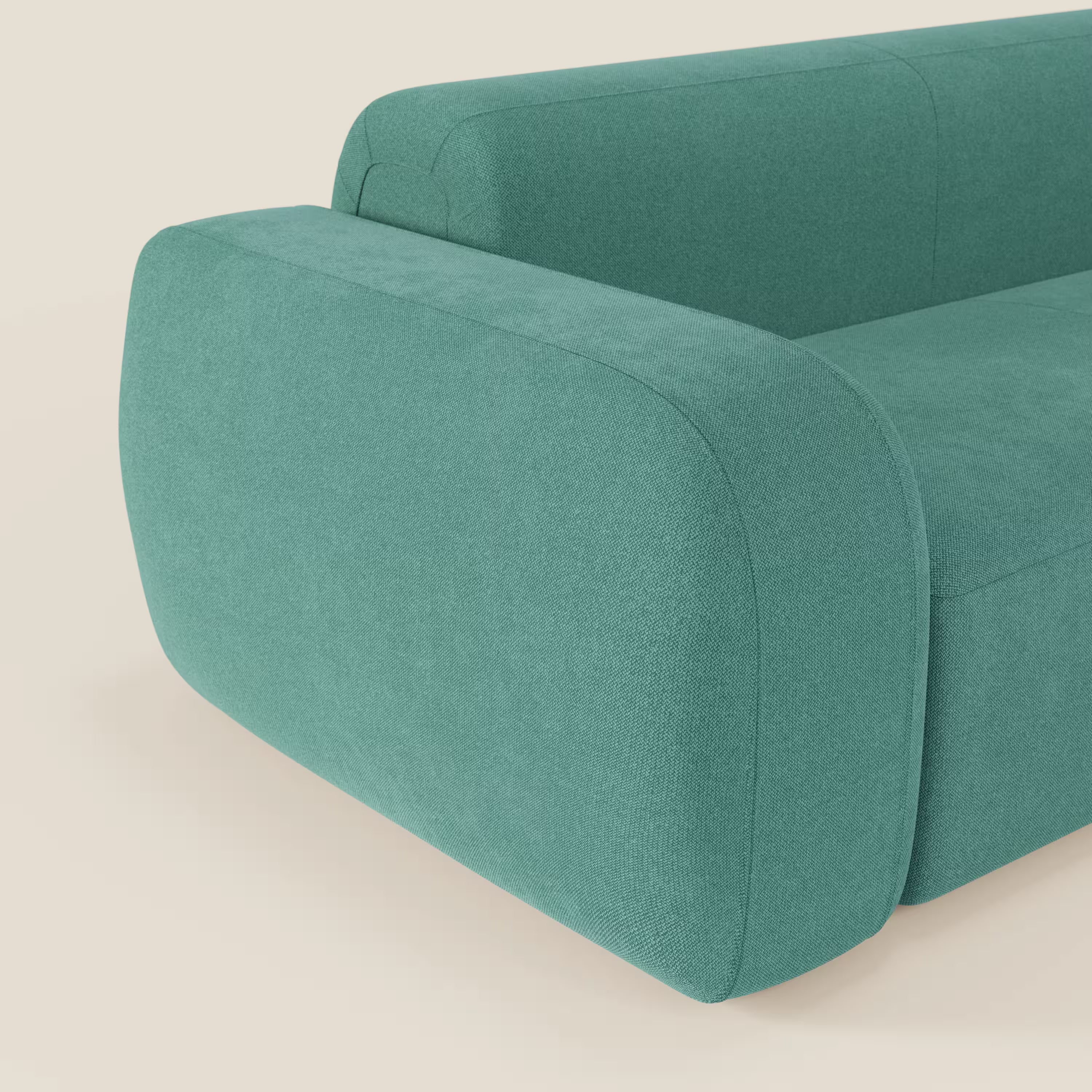Primo piano del divano componibile BonBon Divano di Divani.Store in tessuto smacchiabile T23 verde acqua, caratterizzato da bordi arrotondati, imbottitura morbida, bracciolo spesso e curvo e stile minimalista con pouf terminale.