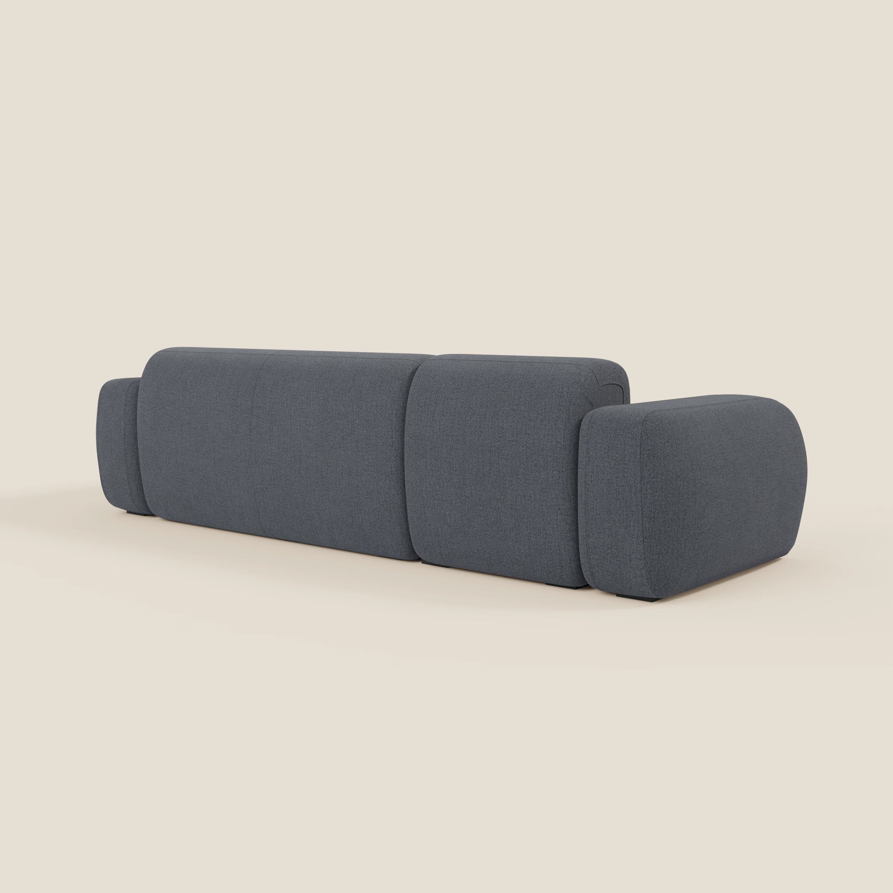 Il BonBon Divano modulare componibile - Composizione Spaccamattone di Divani.Store, in smacchiabile grafite T23 blu, è caratterizzato da cuscini e braccioli arrotondati e squadrati, dal design minimalista e senza gambe visibili, su uno sfondo beige chiaro.
