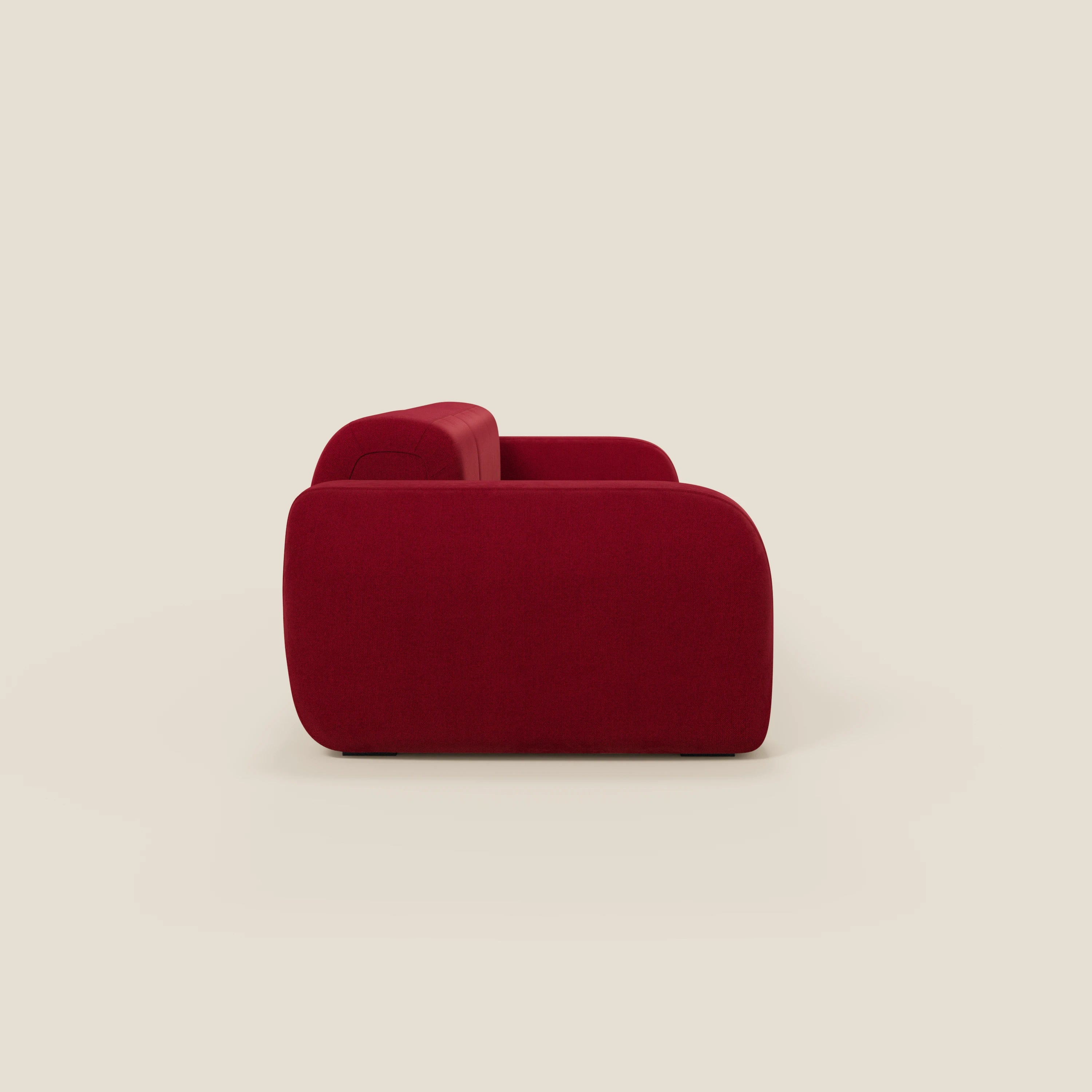 Il divano componibile BonBon - Composizione Spaccamattone di Divani.Store, presentato in tessuto antimacchia T23 bordeaux, presenta un profilo moderno e minimalista con bordi arrotondati, una spessa imbottitura e un design senza gambe su uno sfondo beige.