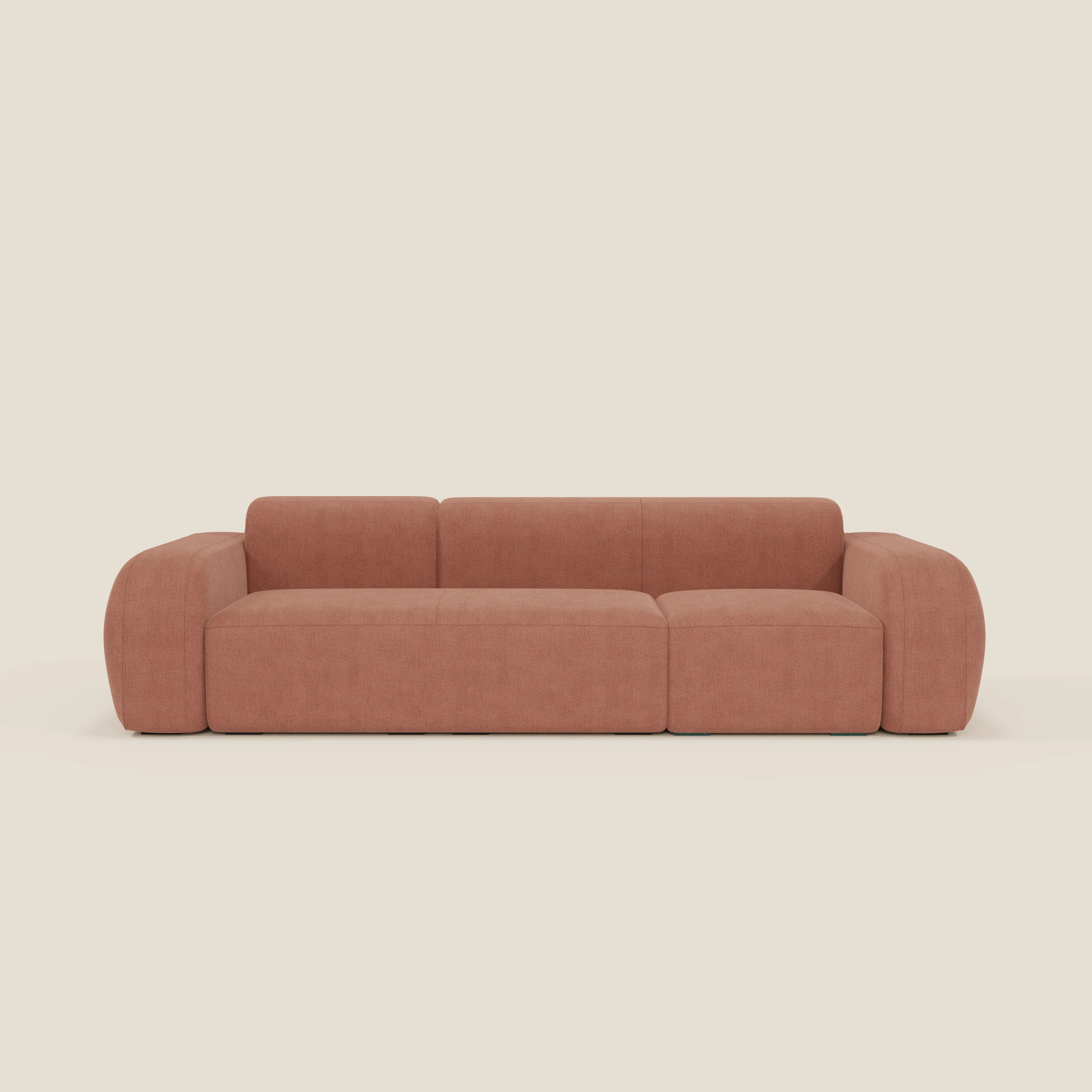 Il divano componibile BonBon - Composizione Spaccamattone di Divani.Store è caratterizzato da braccioli e schienale arrotondati in tessuto antimacchia T23 pesca, su uno sfondo beige tinta unita che ne evidenzia il design a blocchi e imbottito.