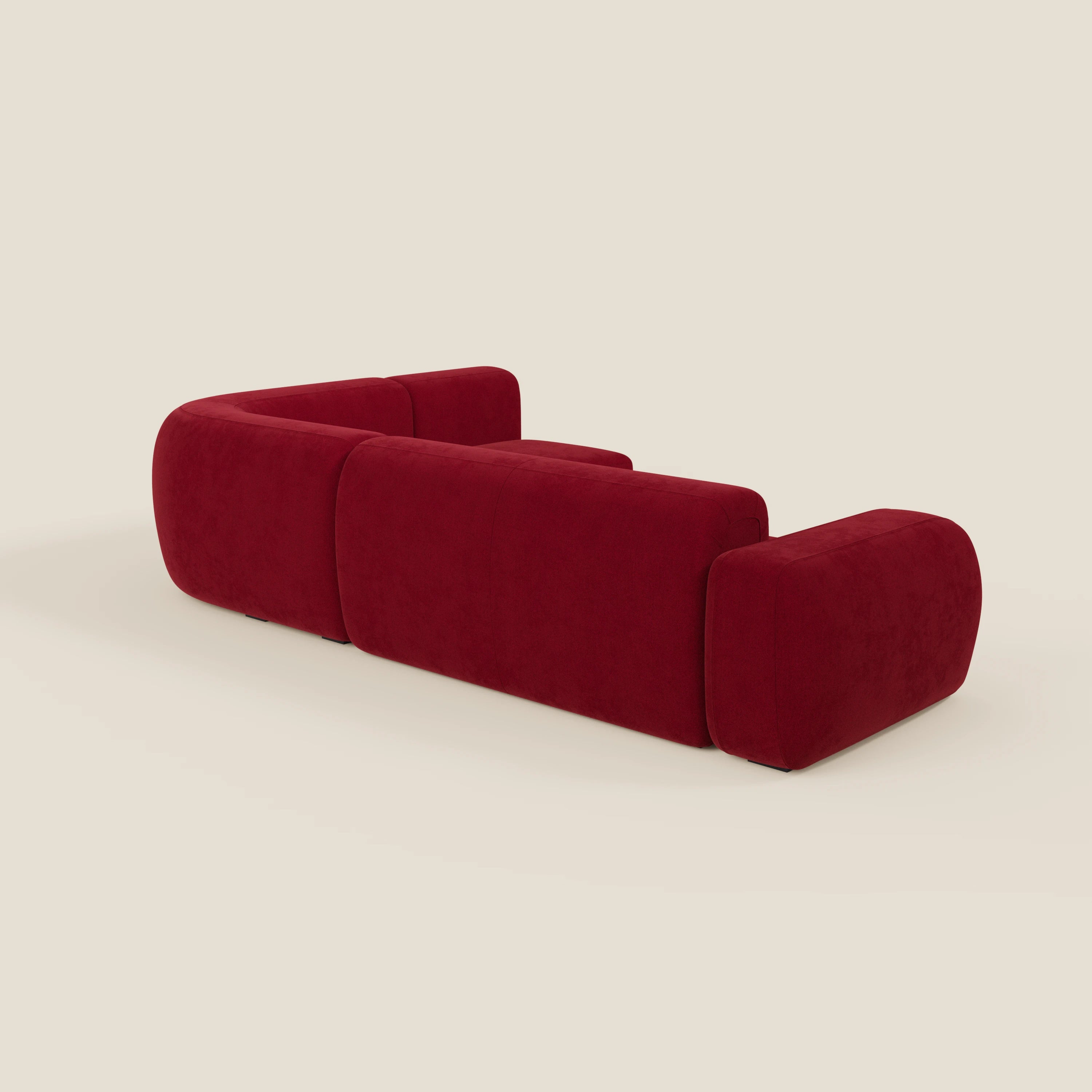Il divano angolare componibile e modulare BonBon di Divani.Store in tessuto antimacchia T23 bordeaux è caratterizzato da spessi cuscini arrotondati, braccioli, profilo basso e linee pulite in un design moderno e minimalista senza gambe a vista.