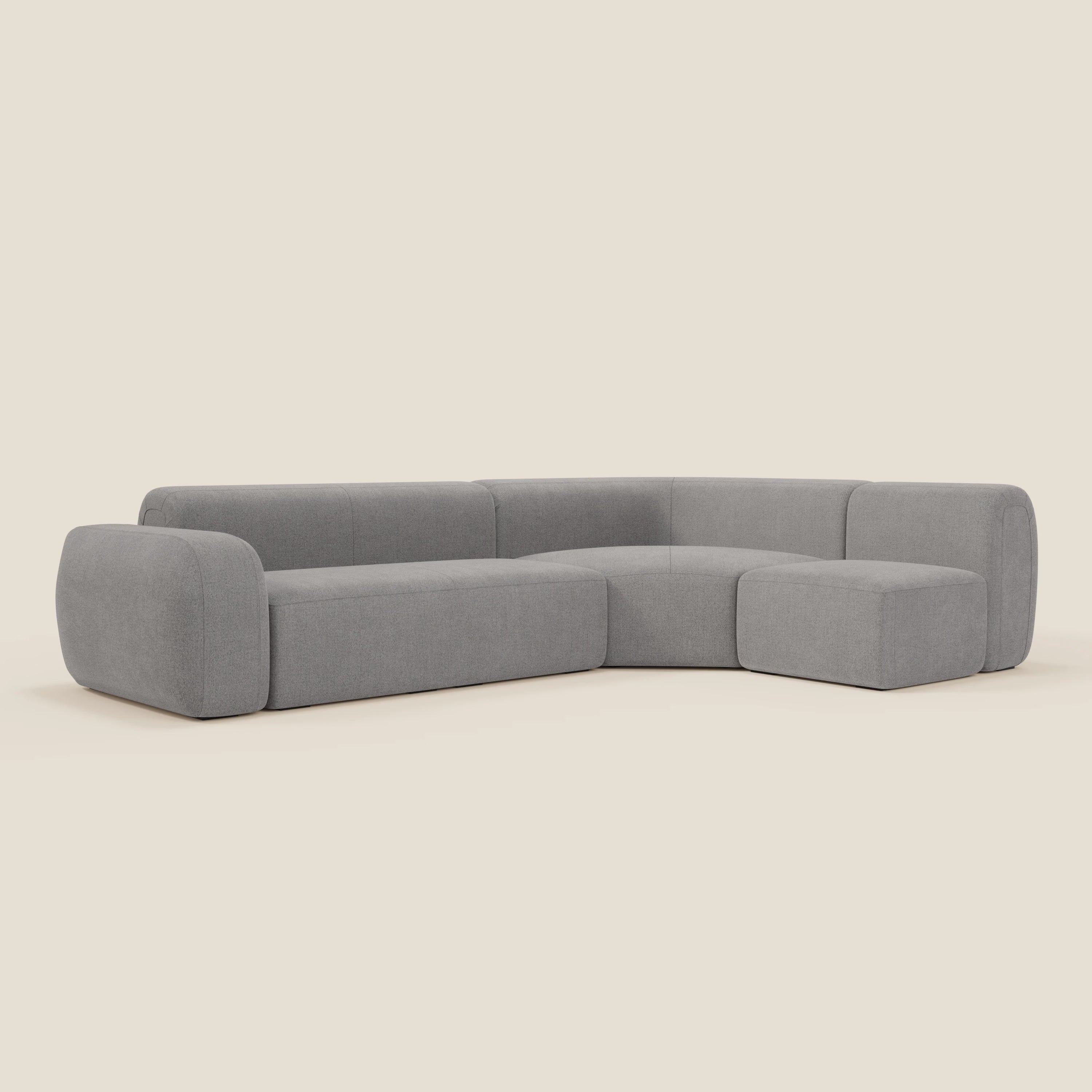 Il divano angolare componibile e modulare BonBon di Divani.Store in tessuto antimacchia T23 grigio ha un design moderno a forma di L, braccioli e schienale bassi e arrotondati, cuscini morbidi e linee pulite per un'ampia seduta.