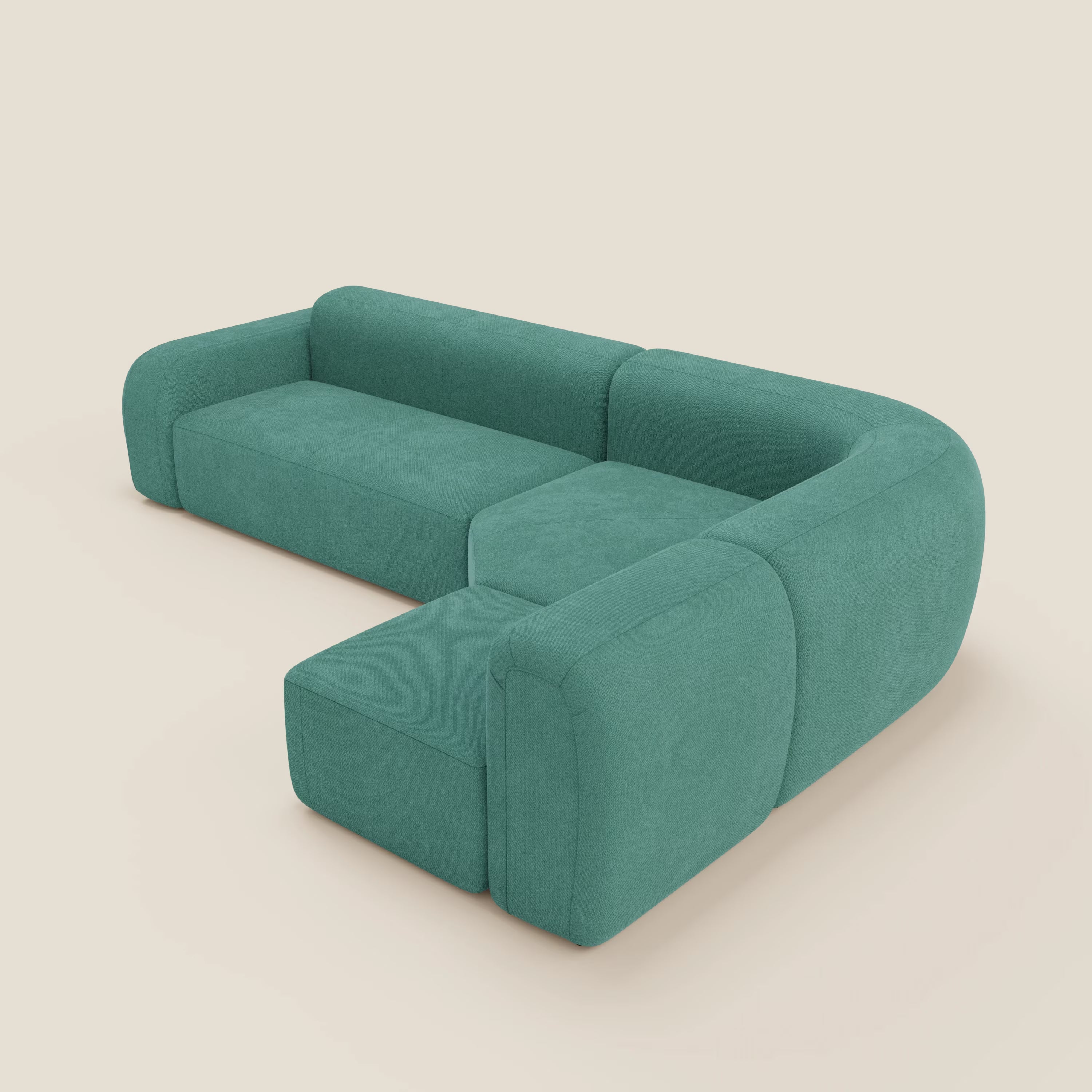 Il divano angolare componibile e modulare BonBon di Divani.Store, in tessuto smacchiabile T23 verde acqua, è caratterizzato da una moderna forma a L con schienale basso, spessi braccioli imbottiti, chaise allungata e bordi lisci e arrotondati su uno sfondo crema chiaro.