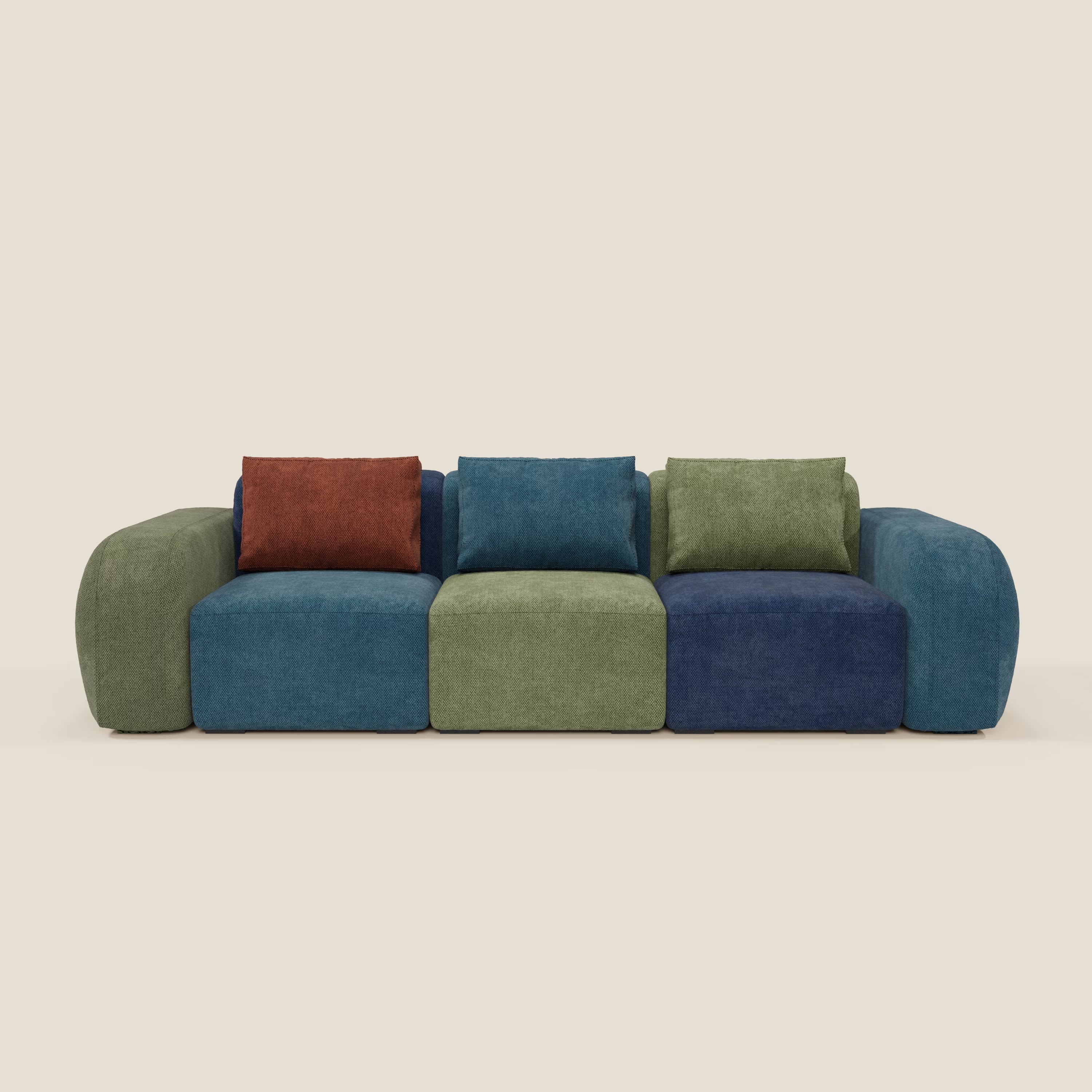 Il divano componibile 3 sedute BonBon - edizione Grande Fratello di Divani.Store è un moderno divano componibile con sedute blu e verdi, cuscini di schienale multicolore e braccioli arrotondati. Realizzato in Italia, si staglia su uno sfondo beige chiaro.