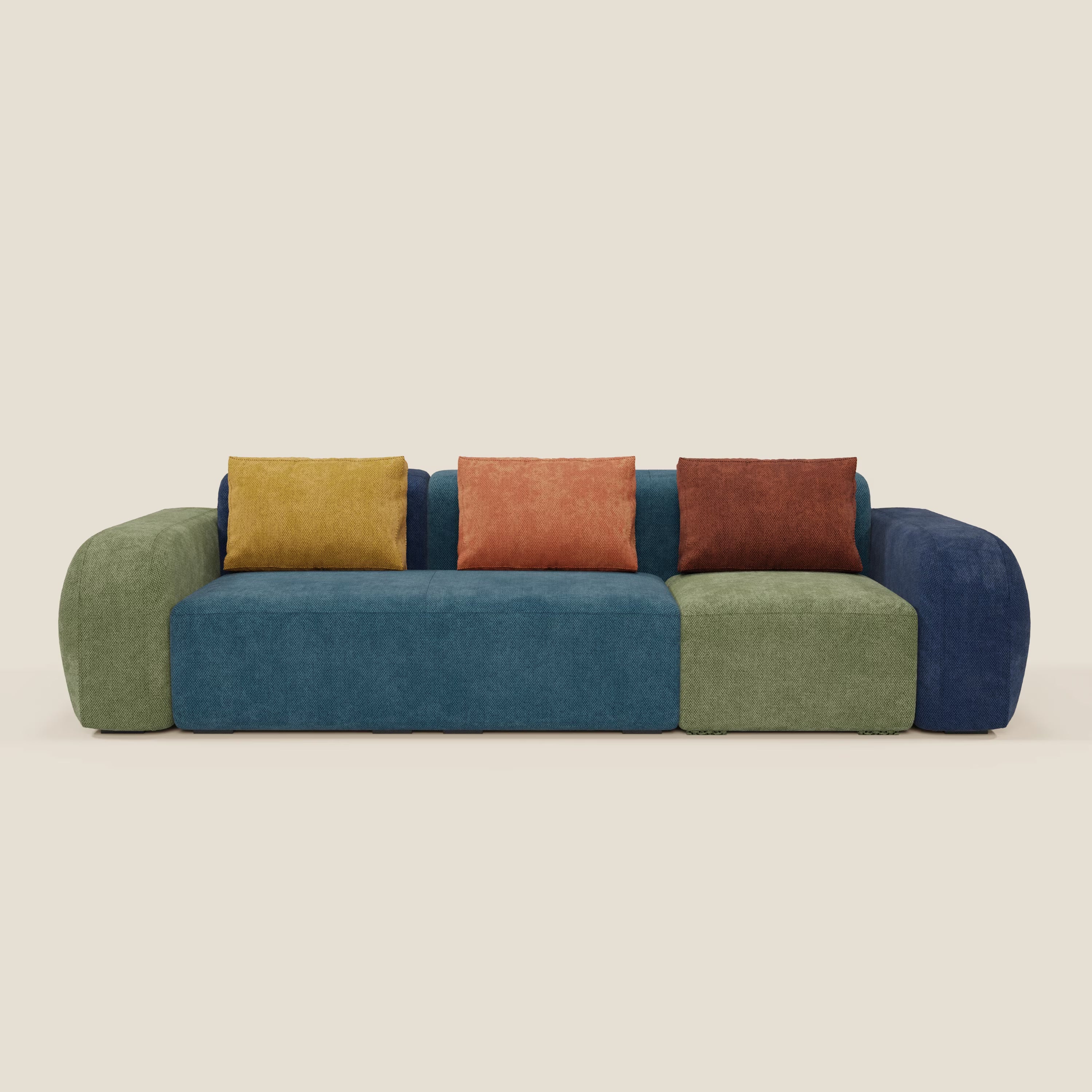 Il divano componibile BonBon a 4 posti - edizione Grande Fratello di Divani.Store è caratterizzato da cuscini blu e verdi, di forma arrotondata, e da quattro cuscini quadrati nei colori senape, arancio, terracotta e blu scuro, realizzati in uno stile italiano senza tempo.