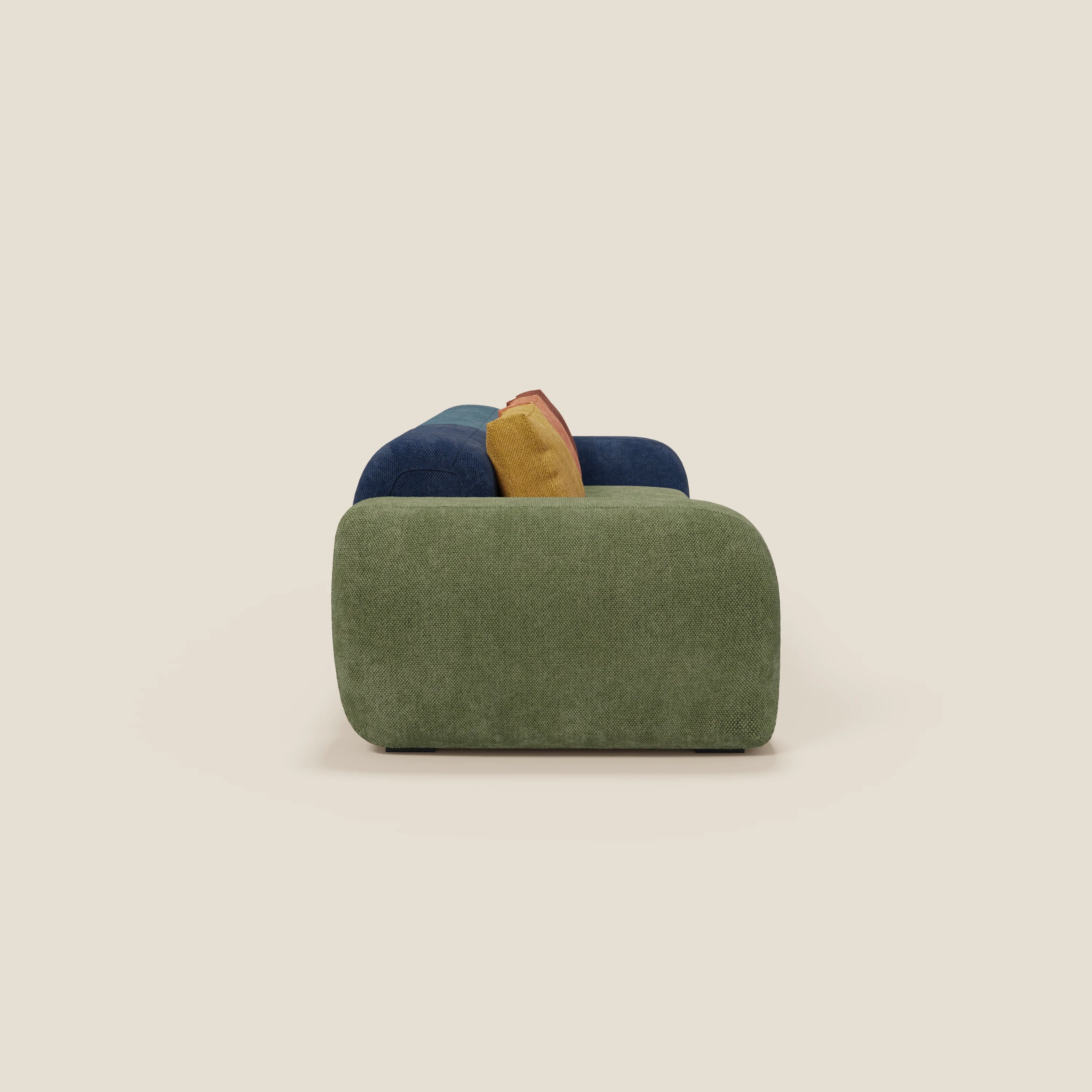 Il divano componibile BonBon 4 posti - edizione Grande Fratello di Divani.Store, visto di lato, è caratterizzato da un'imbottitura verde tenue con cuscini giallo senape e rosso ruggine, di produzione italiana, su uno sfondo beige chiaro.