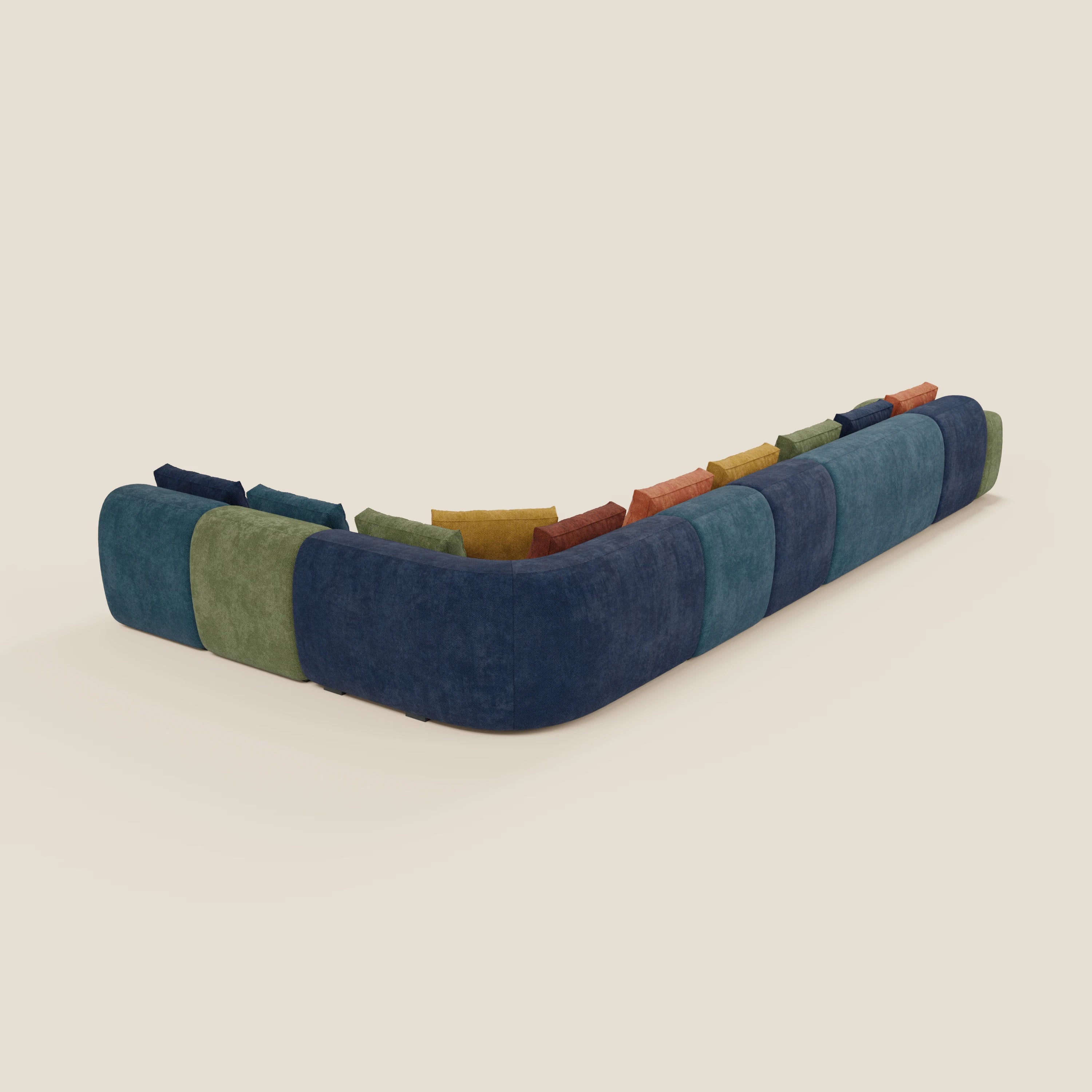 Il BonBon Grande Fratello Edition di Divani.Store è un grande divano modulare a L con angolo curvo, rivestito con ampi pannelli di colore blu scuro, verde e verde acqua e dotato di cuscini di schienale in blu, verde, arancio e senape.