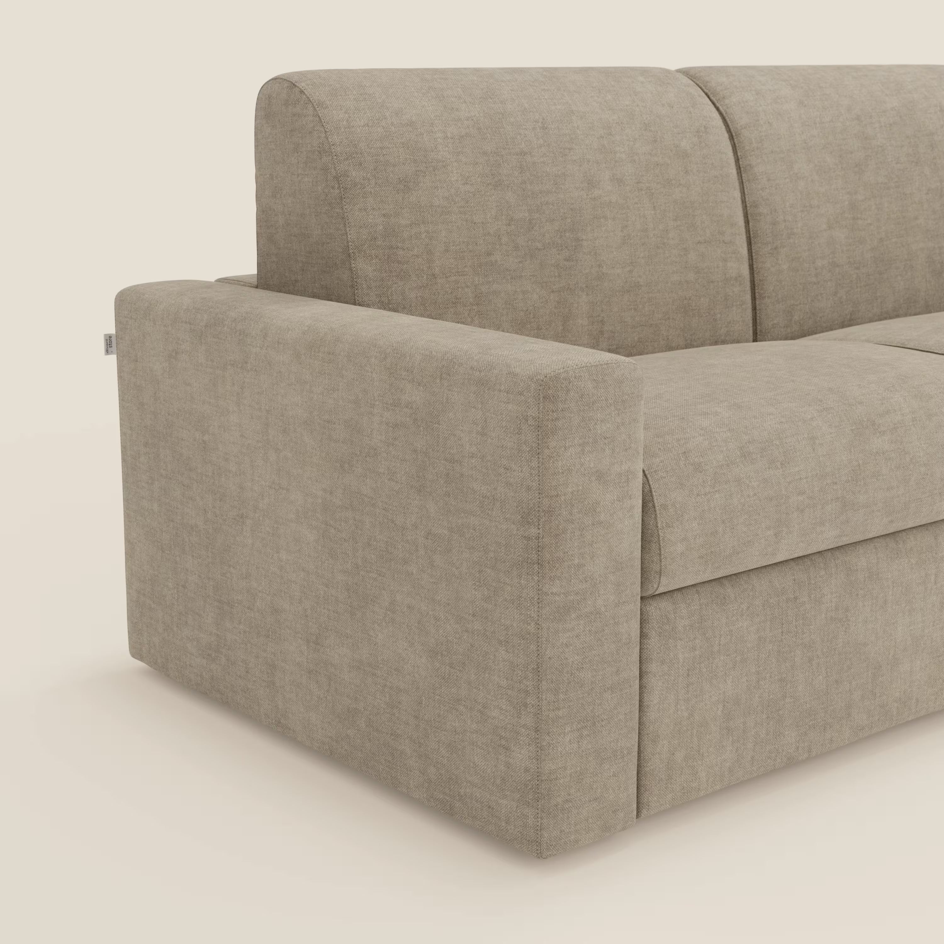 Un primo piano del letto matrimoniale Diomede Divano di Divani.Store in velluto T35 beige easy-clean mostra le linee pulite del design moderno, la forma squadrata e i cuscini morbidi sul bracciolo sinistro, sullo schienale e sulla seduta su uno sfondo neutro.