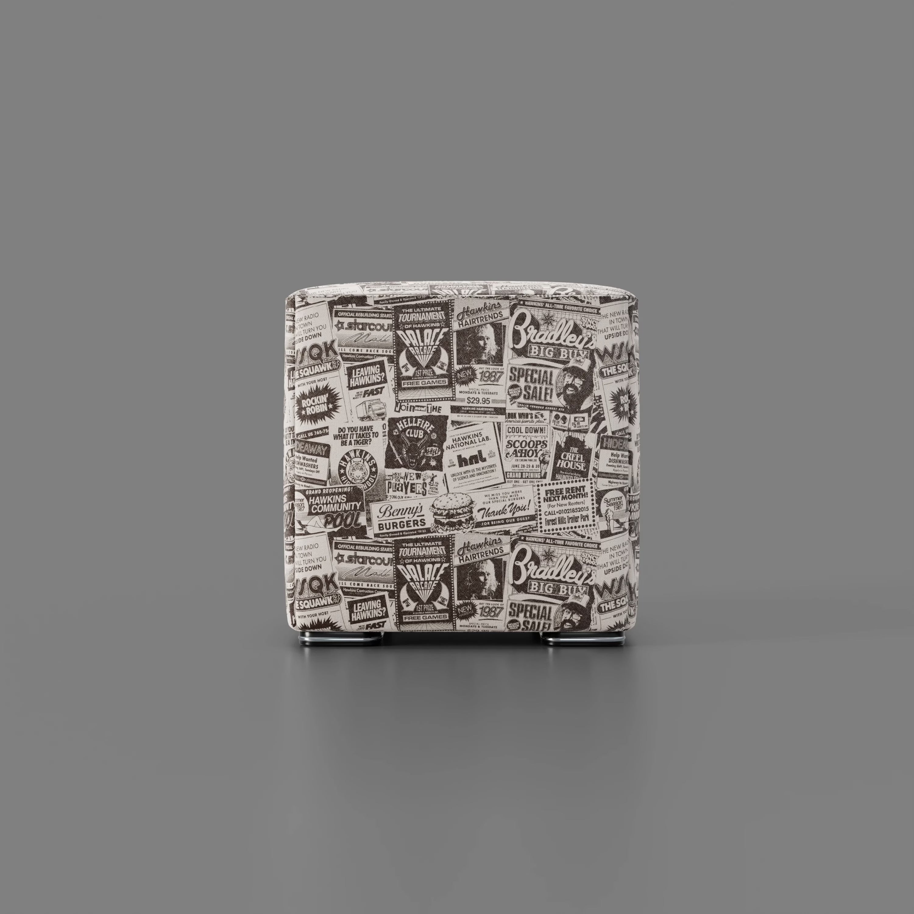 Il pouf Cube Hawkins Post Stranger Things - Limited Edition Netflix di Divani.Store, caratterizzato da stampe vintage in bianco e nero e da corte gambe metalliche, poggia su una superficie grigia liscia su uno sfondo grigio semplice.
