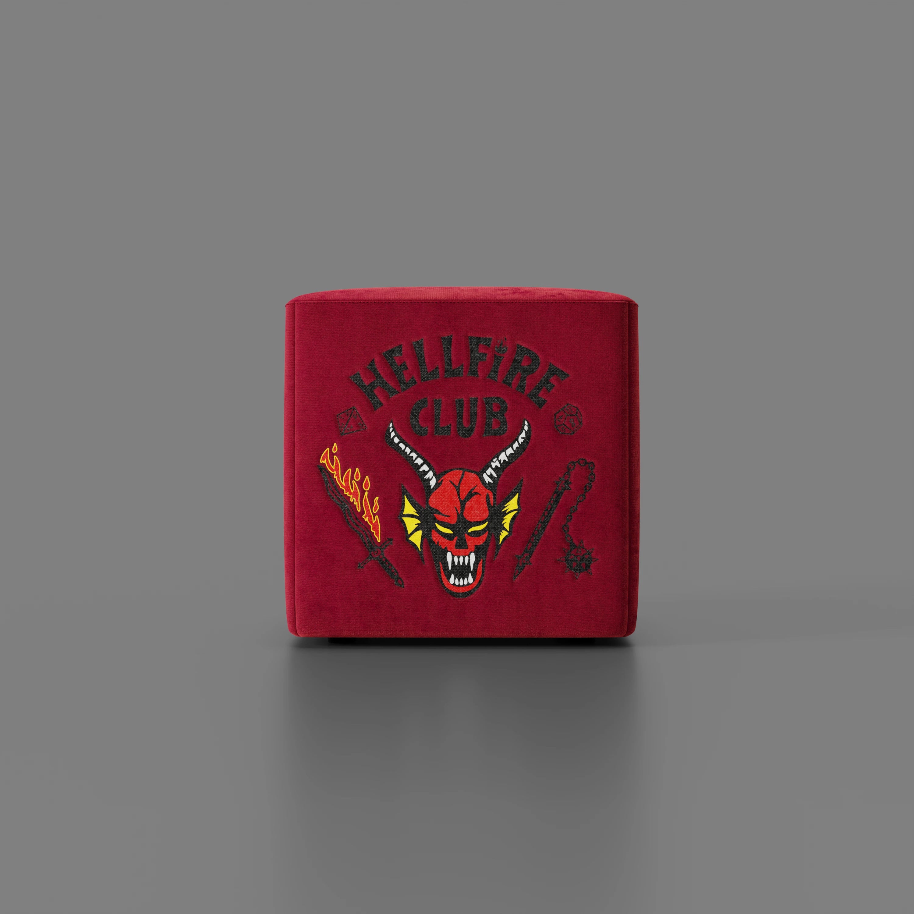 Il pouf Cube Hellfire club Stranger Things Edition di Divani.Store è un pouf artigianale rosso con la scritta "Hellfire Club", un volto di demone cornuto, una spada infuocata e un flail su uno sfondo grigio.