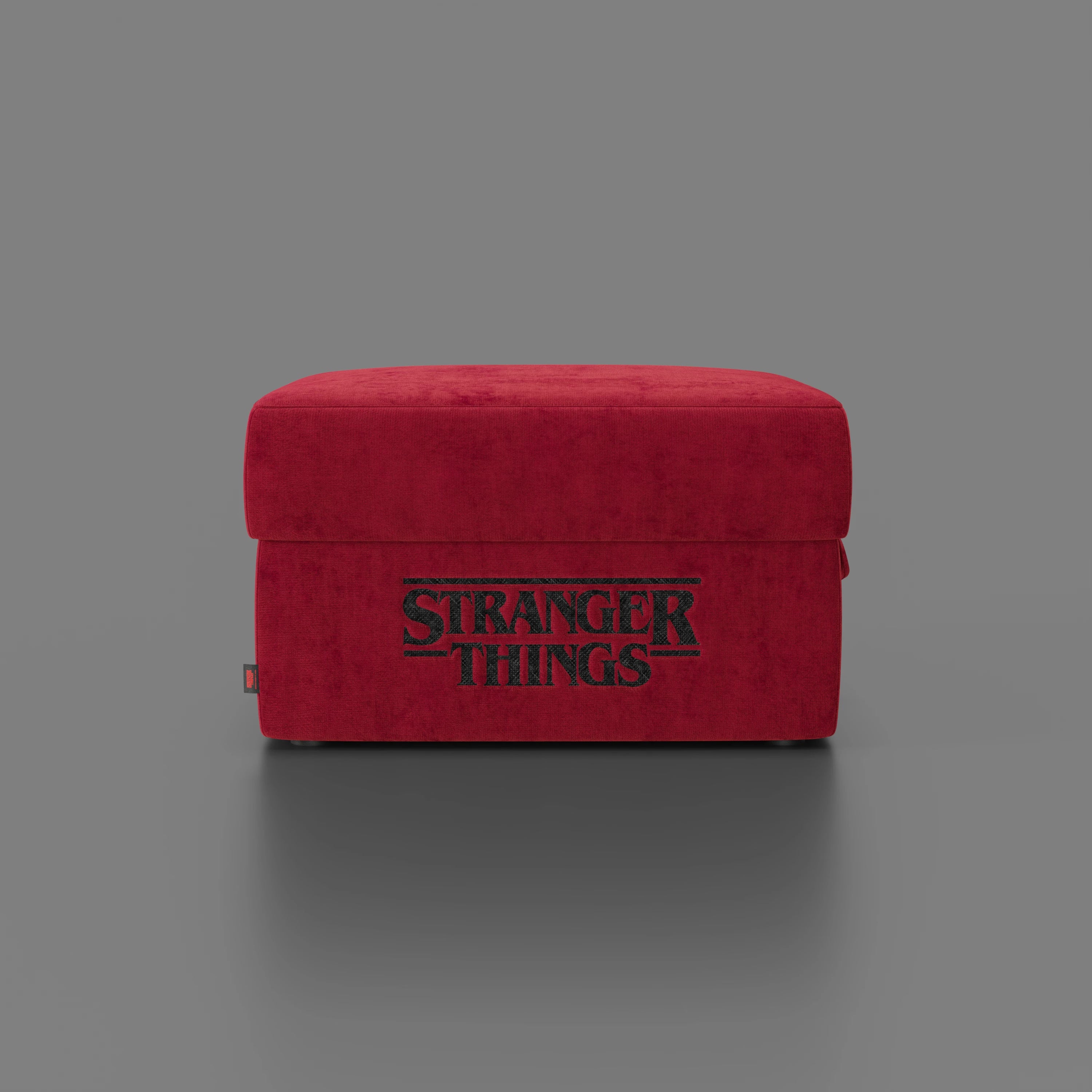 Il pouf rettangolare Sun contenitore Stranger Things Edition di Divani.Store (60x80 cm), di colore rosso e su sfondo grigio, presenta il logo della serie su un tessuto morbido e antimacchia dal design semplice e moderno.