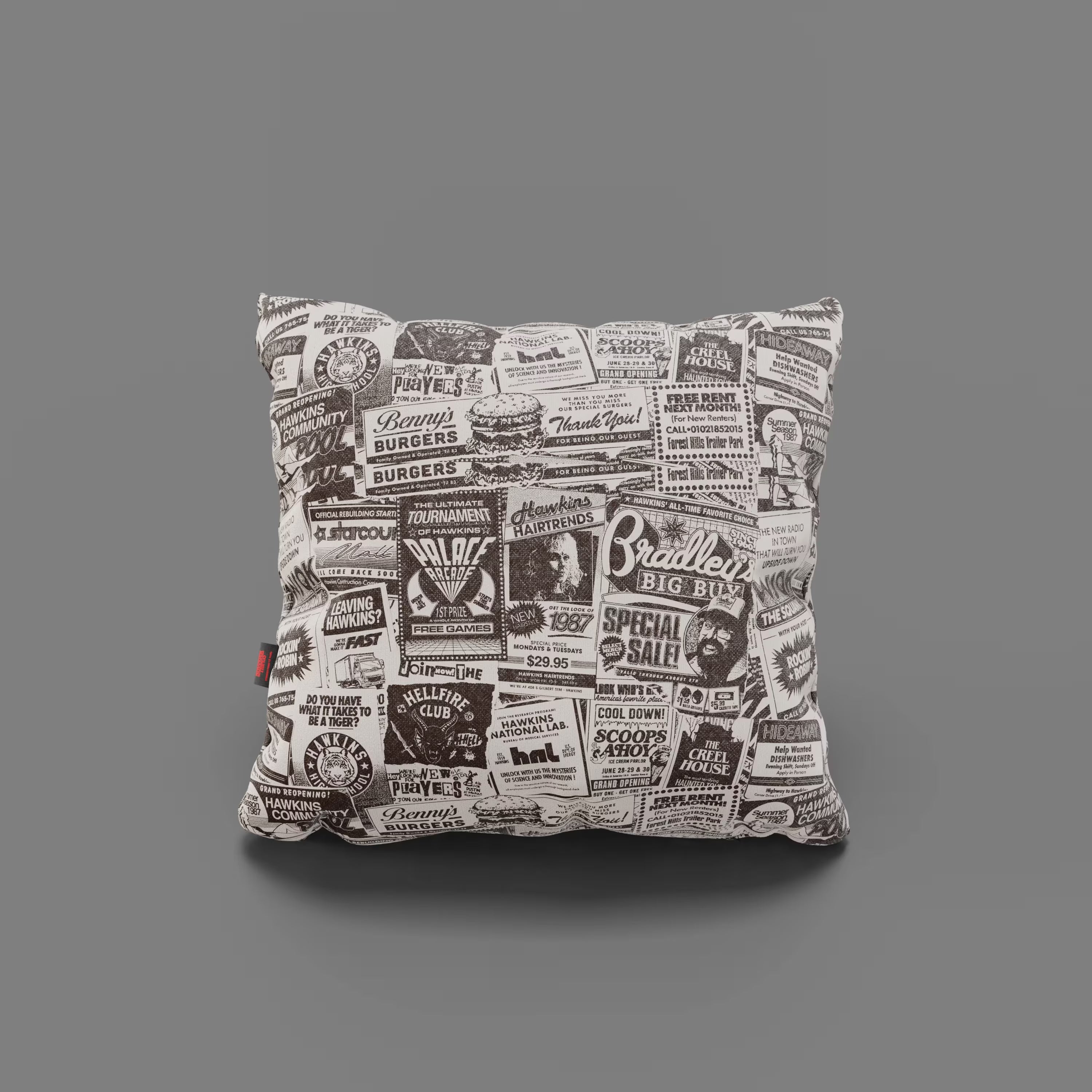 Il Cuscino Hawkins Post Stranger Things - Limited Edition 45x45 cm di Divani.Store è un cuscino quadrato con sfondo bianco e stampe pubblicitarie retrò nere, ispirate ai menu vintage delle tavole calde della collezione Stranger Things.