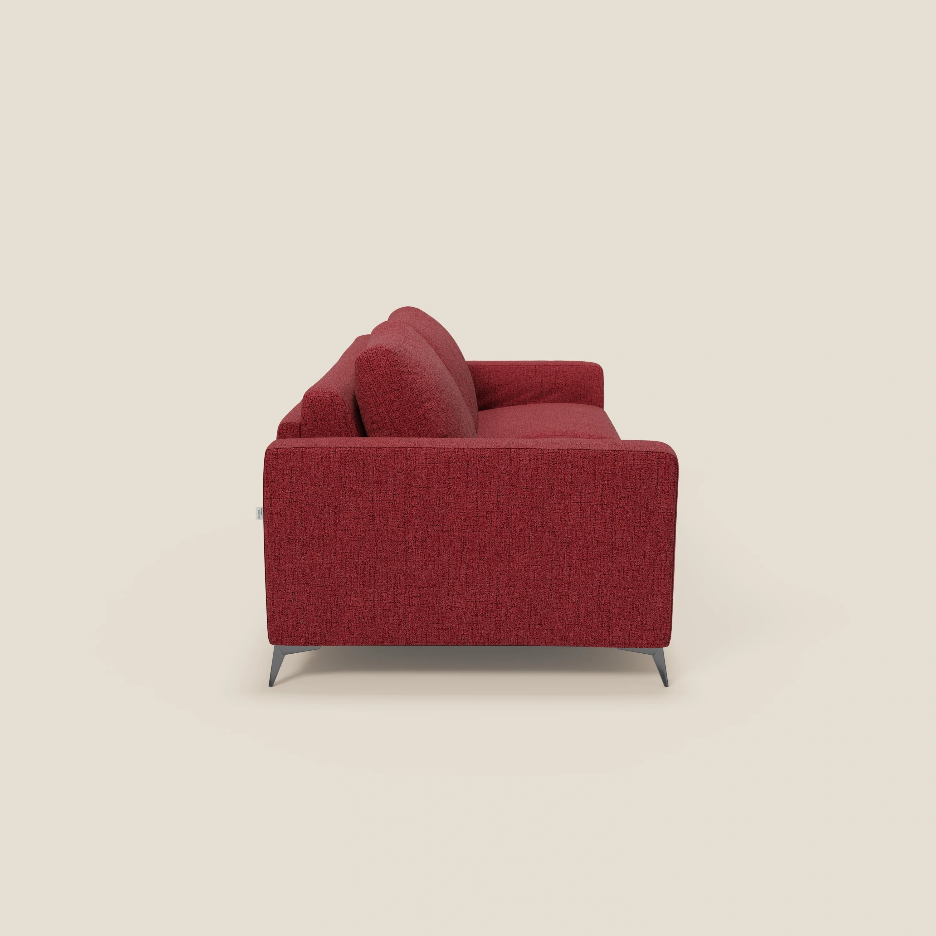 Vista laterale del letto matrimoniale Alaya Divano di Divani.Store in tessuto impermeabile rosso T03, con due cuscini di seduta e schienale, braccioli dritti, gambe corte e un design semplice su sfondo beige.