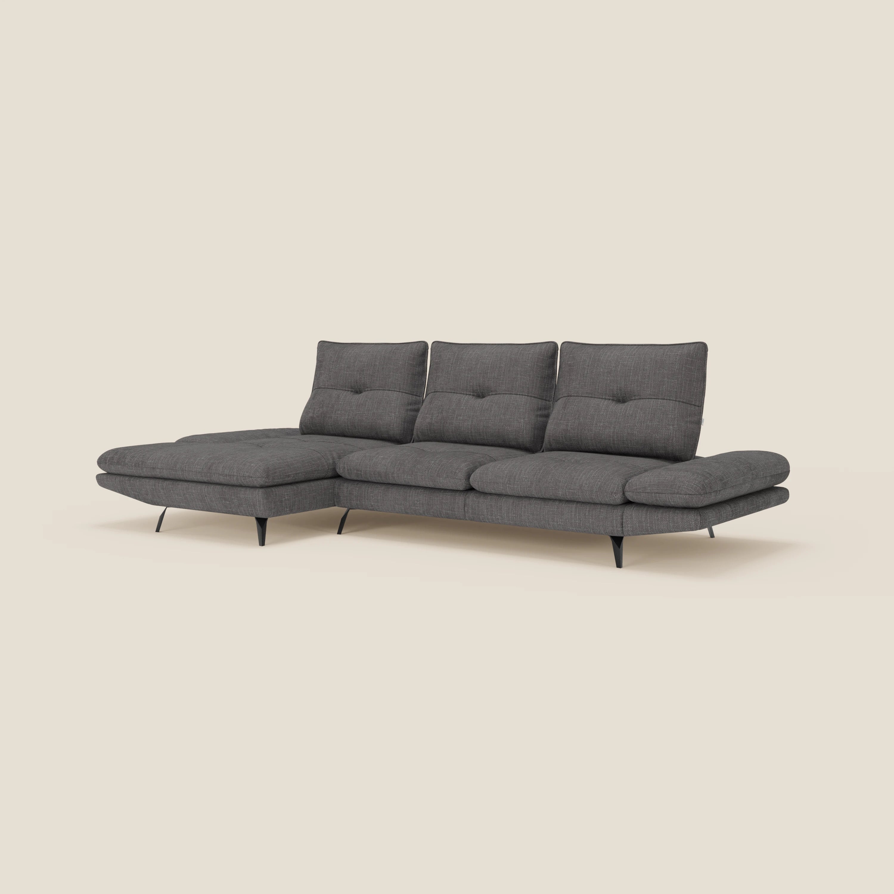 Ardex Divano con penisola di Divani.Store è caratterizzato da tre sedute imbottite, un'ampia chaise longue, schienali e braccioli regolabili in elegante tessuto impermeabile T06 antracite e sottili gambe in metallo nero, perfette per ambienti minimalisti.