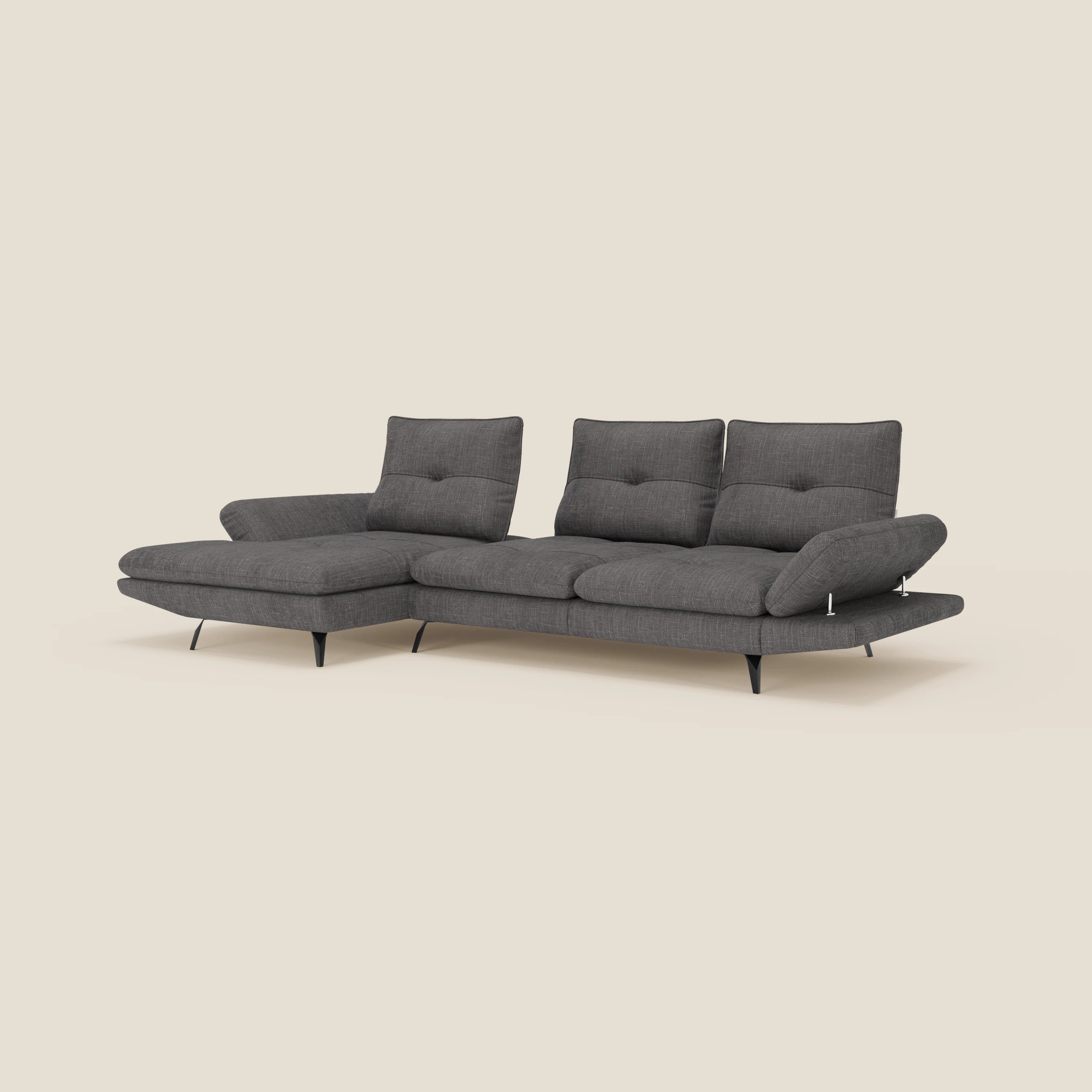 L'Ardex Divano con penisola di Divani.Store in tessuto impermeabile T06 antracite ha schienali traslanti, braccioli regolabili, seduta a tre posti e chaise longue sinistra. Gambe nere in metallo su sfondo beige chiaro completano il look moderno.