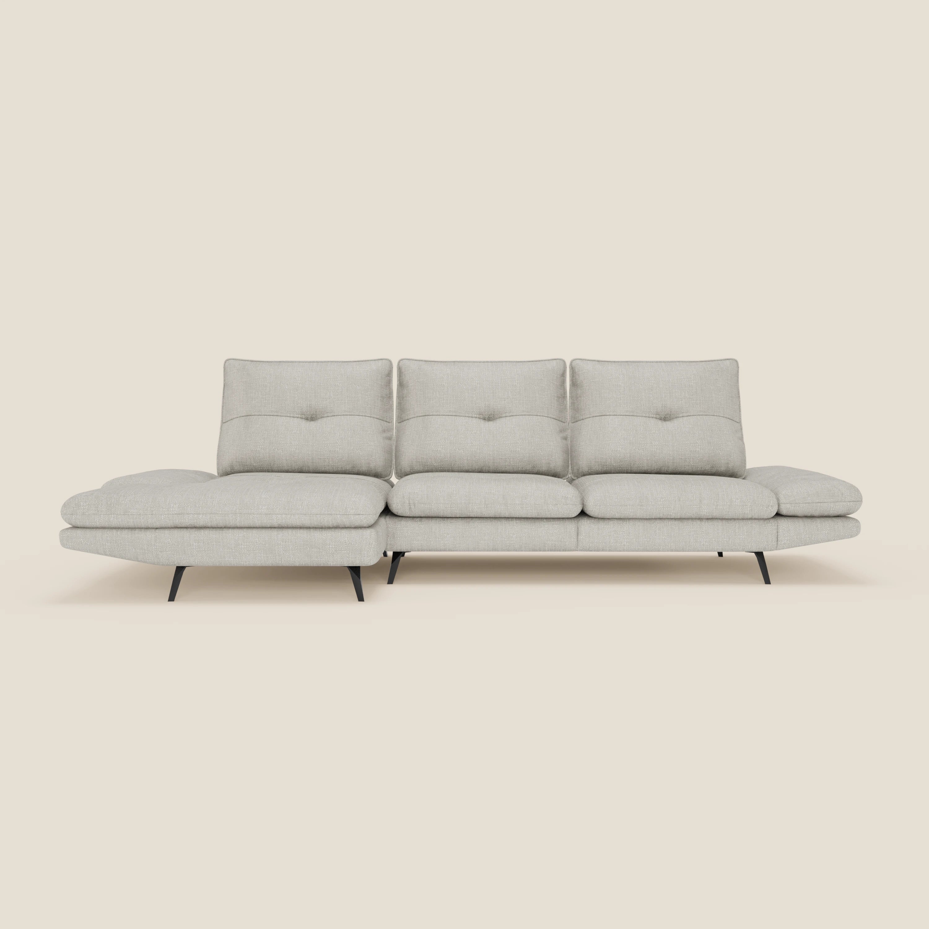 Ardex Divano con penisola di Divani.Store è caratterizzato da schienali scorrevoli, braccioli regolabili ed elegante tessuto impermeabile T06 grigio chiaro, con chaise longue sinistra e sottili gambe in metallo nero, su uno sfondo bianco sporco.