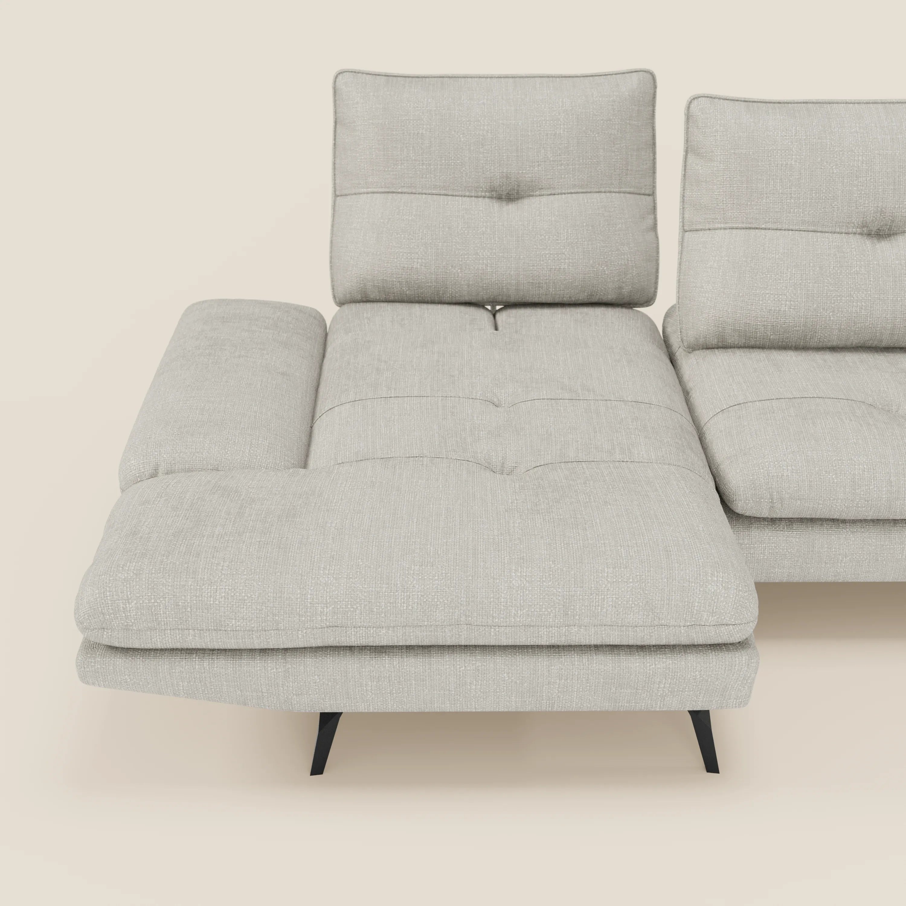 L'Ardex Divano con penisola di Divani.Store è caratterizzato da un elegante tessuto impermeabile grigio chiaro T06, schienali scorrevoli, braccioli regolabili e gambe sottili e distanziate in nero. Il tutto su un solido sfondo color crema.