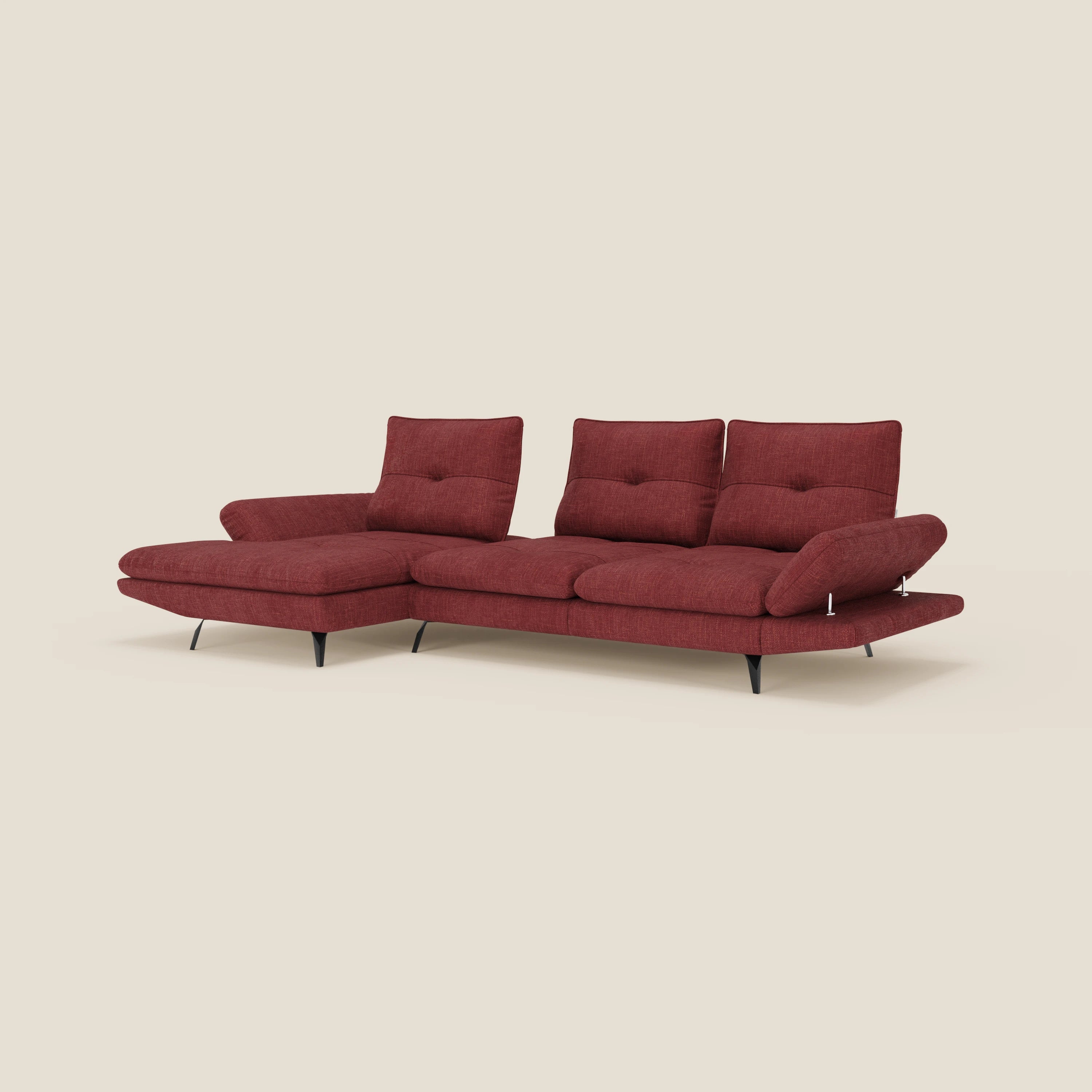 Ardex Divano con penisola di Divani.Store è dotato di tre sedute, una chaise longue, poggiatesta e braccioli regolabili ed è rivestito in un elegante tessuto impermeabile rosso T06. Le sottili gambe in metallo nero completano il look moderno su uno sfondo beige.