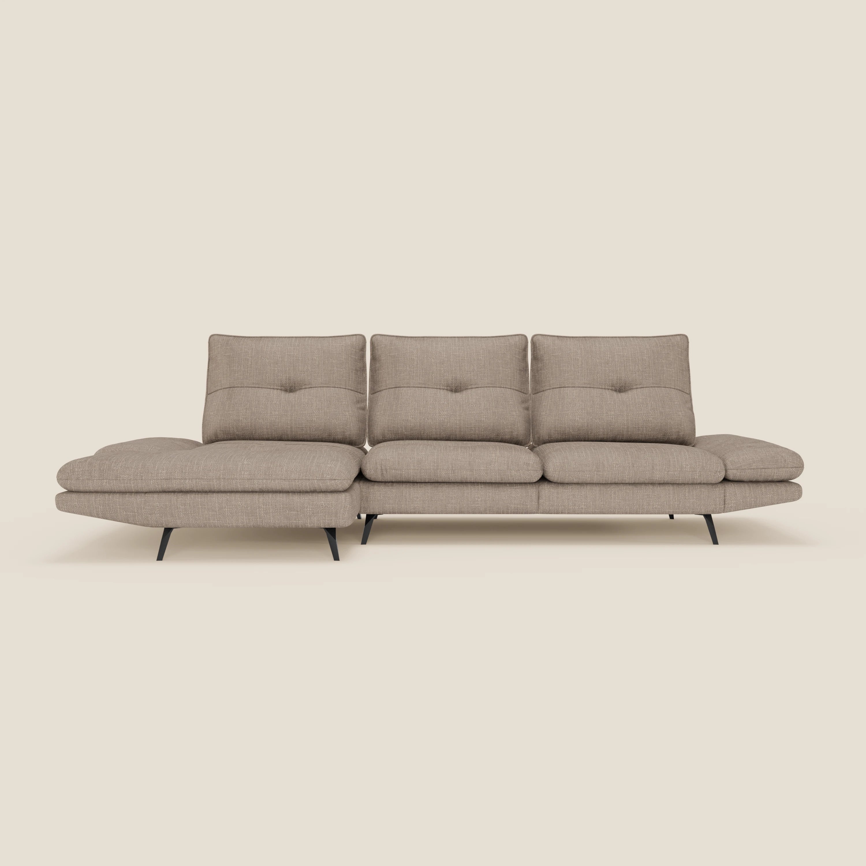 L'Ardex Divano con penisola di Divani.Store è caratterizzato da tre cuscini di schienale con inserti, una chaise longue sul lato sinistro, sottili gambe nere ed è rivestito in un elegante tessuto impermeabile T06 tortora. Il tutto su uno sfondo beige chiaro.