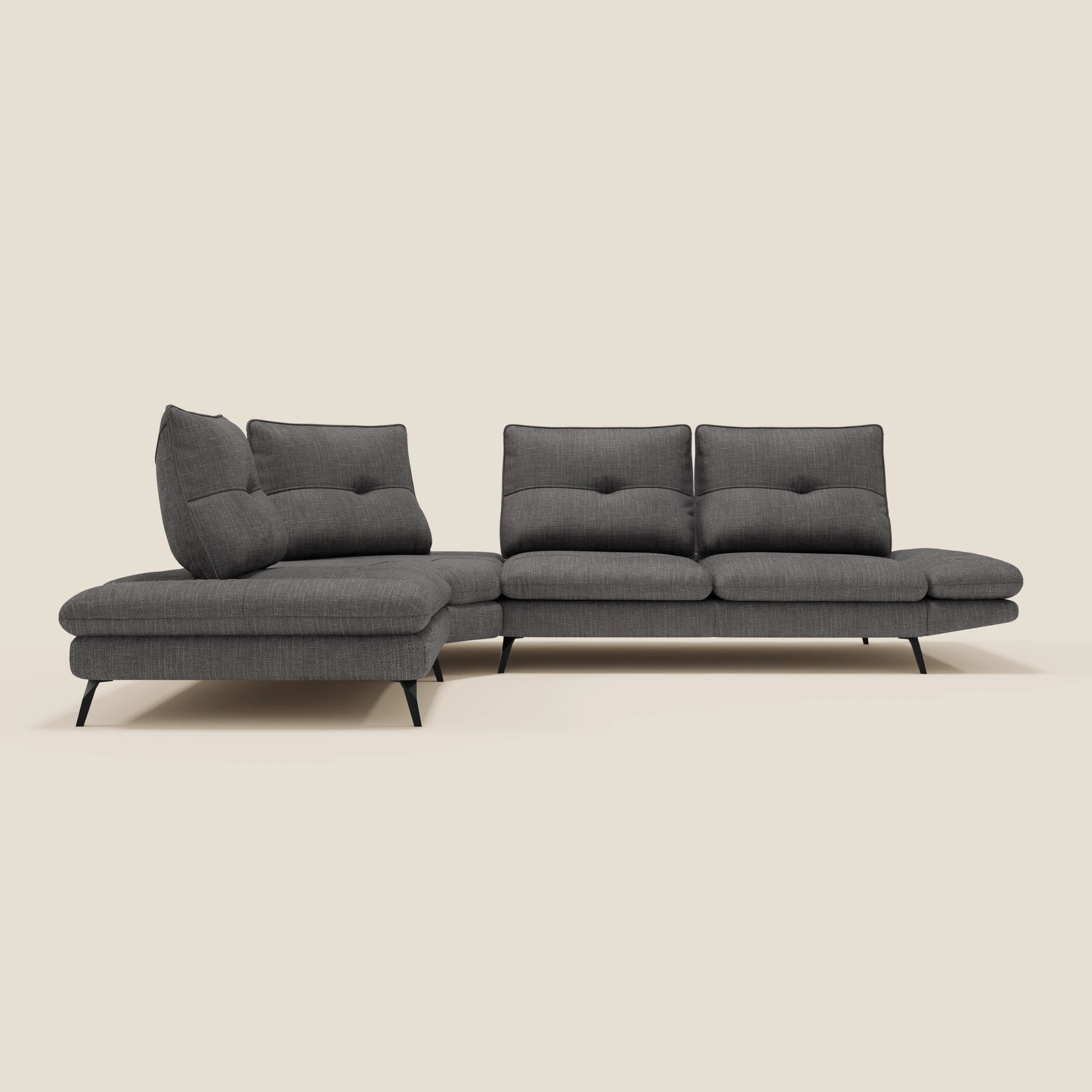 Ardex Divano Angolare di Divani.Store è un moderno divano componibile grigio scuro in tessuto impermeabile T06 antracite, con schienali regolabili, chaise longue sinistra, tre sedute, cuscini trapuntati e sottili gambe in metallo nero su sfondo beige.