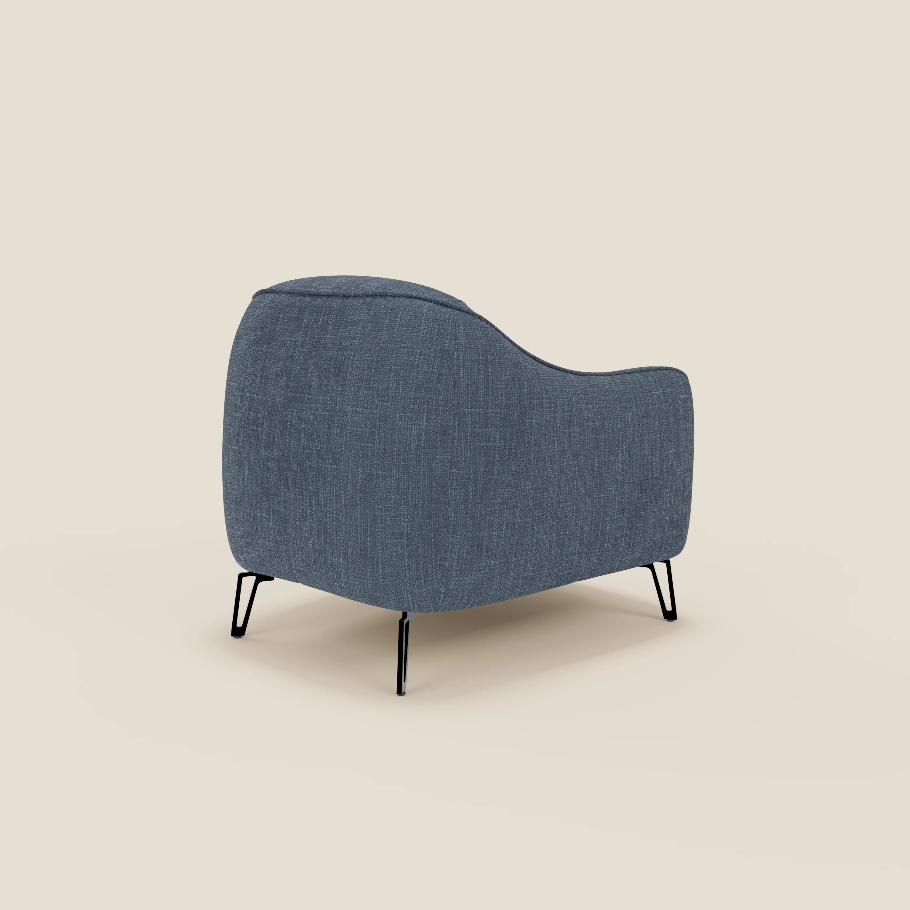 La Poltroncina Avela di Divani.Store, rivestita in morbido e intramontabile tessuto impermeabile blu T06, è caratterizzata da bordi arrotondati e sottili gambe in metallo nero. In figura, sul lato posteriore sinistro, su uno sfondo beige chiaro.