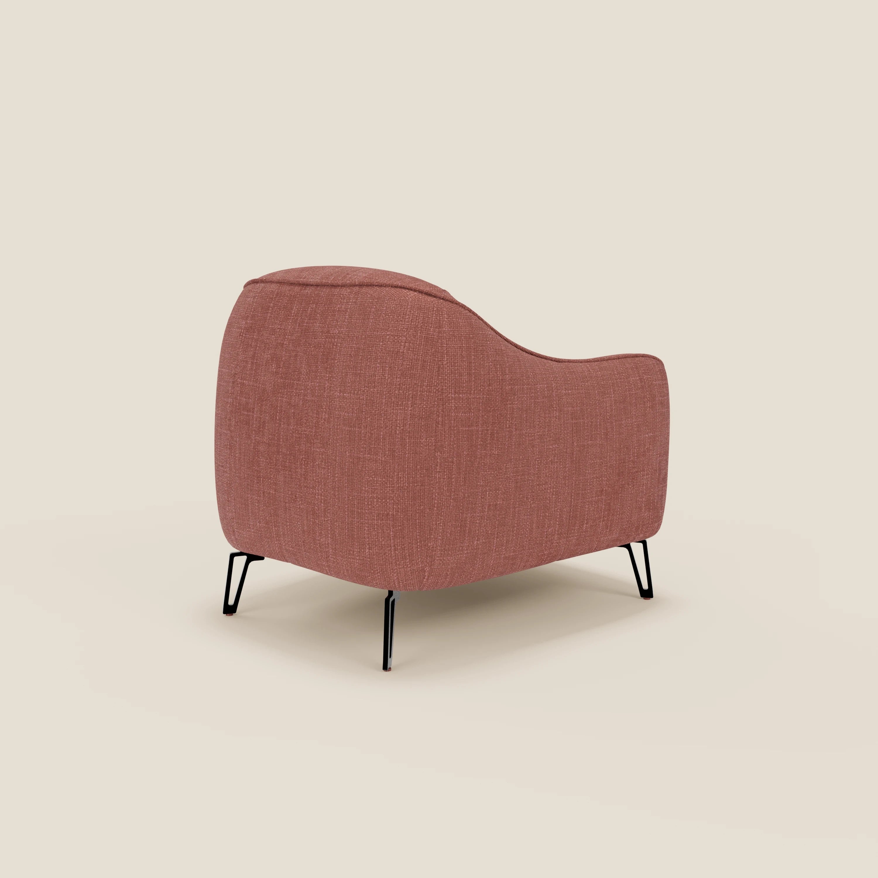 La poltroncina Avela di Divani.Store, caratterizzata da bordi curvi e gambe angolate in metallo nero, è vista di tre quarti dal retro. Rivestita in morbido tessuto corallo impermeabile T06, appare su uno sfondo beige semplice.
