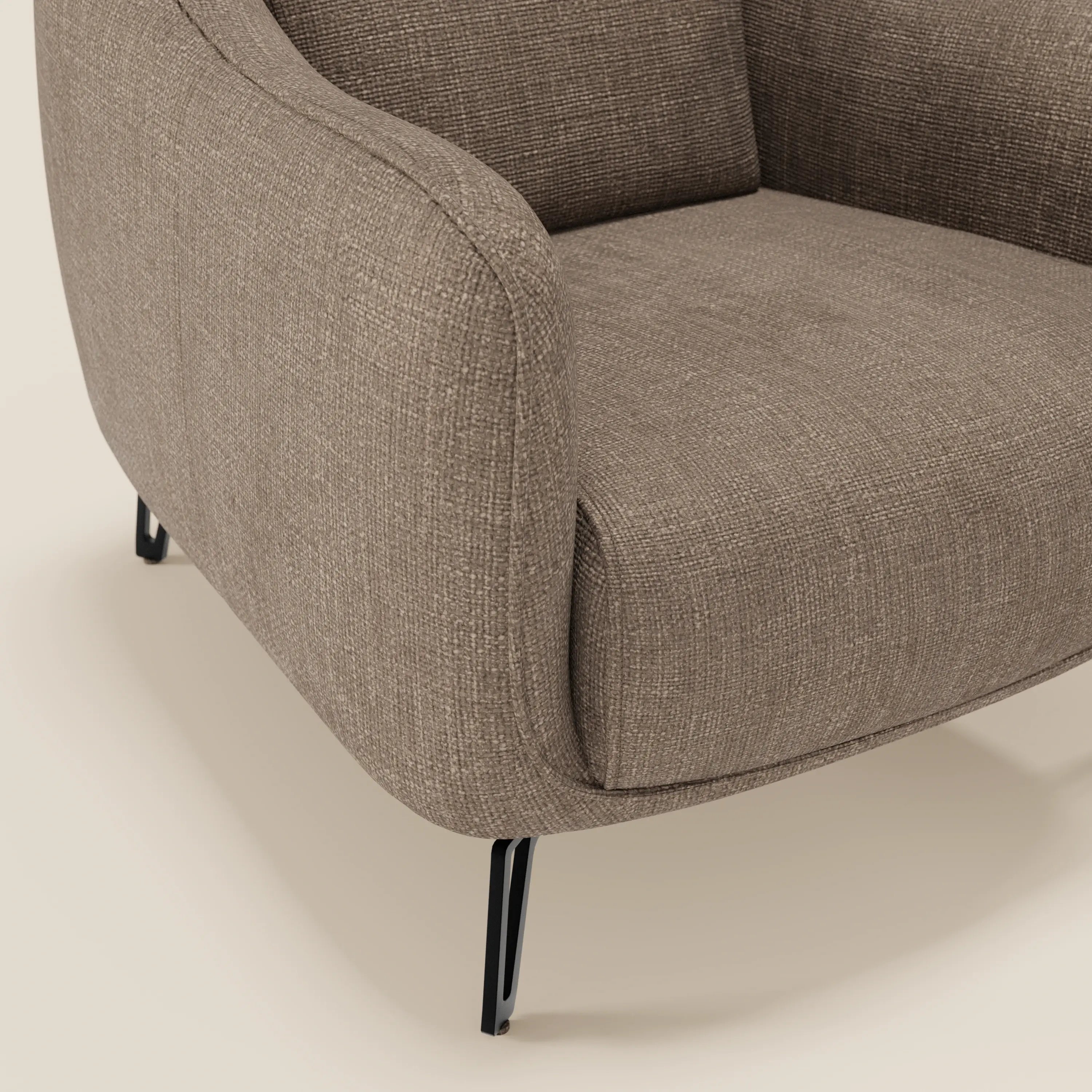 Primo piano di Avela Poltroncina di Divani.Store, una poltrona moderna in tessuto impermeabile T06 marrone testurizzato con eleganti gambe in metallo nero, seduta e schienale imbottiti e arrotondati e braccioli curvi su uno sfondo chiaro.