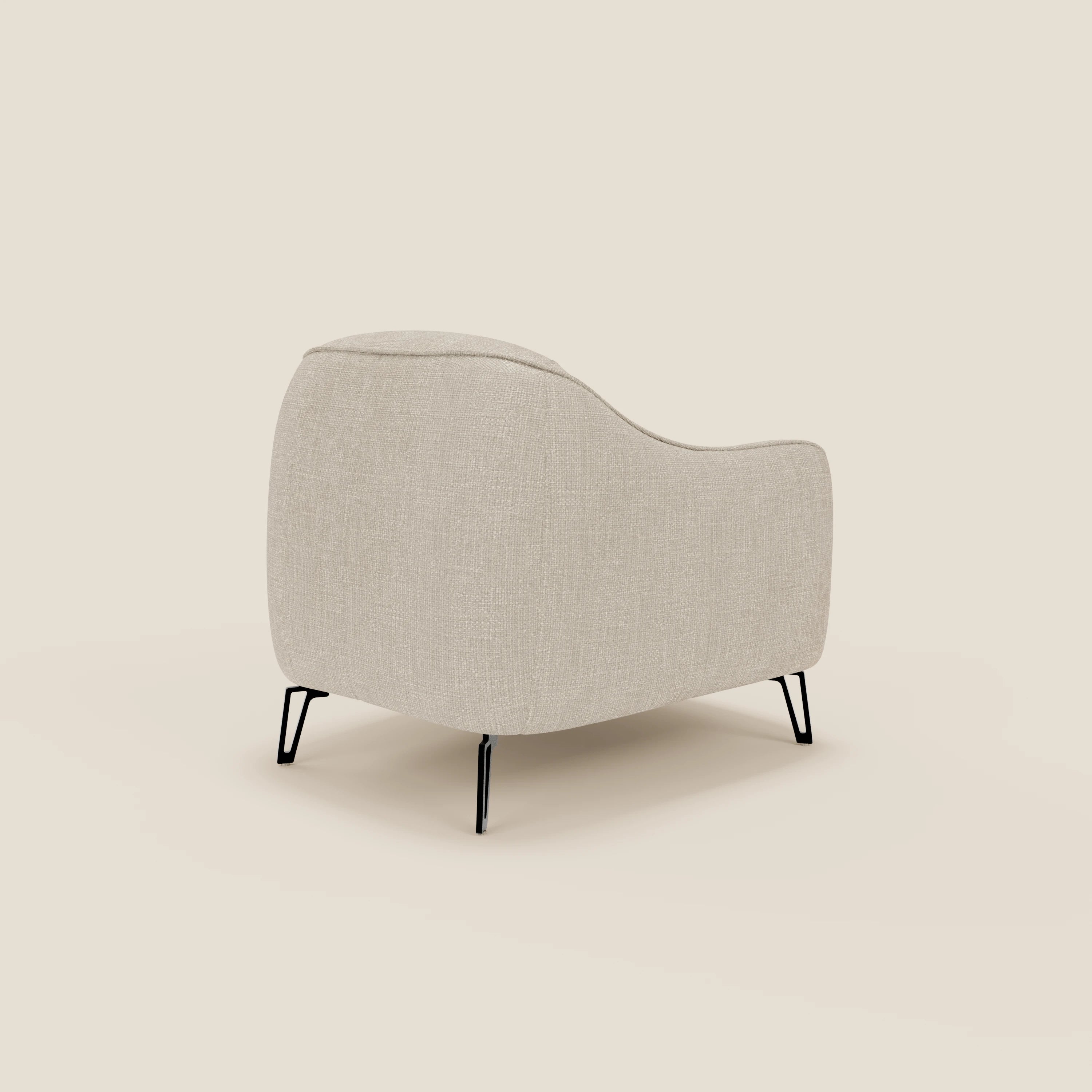 La poltroncina Avela di Divani.Store, in tessuto impermeabile T06 panna, è caratterizzata da spigoli arrotondati, gambe in metallo nero e un comfort senza tempo, mostrato dal retro a sinistra per evidenziare il design moderno e la texture accogliente.