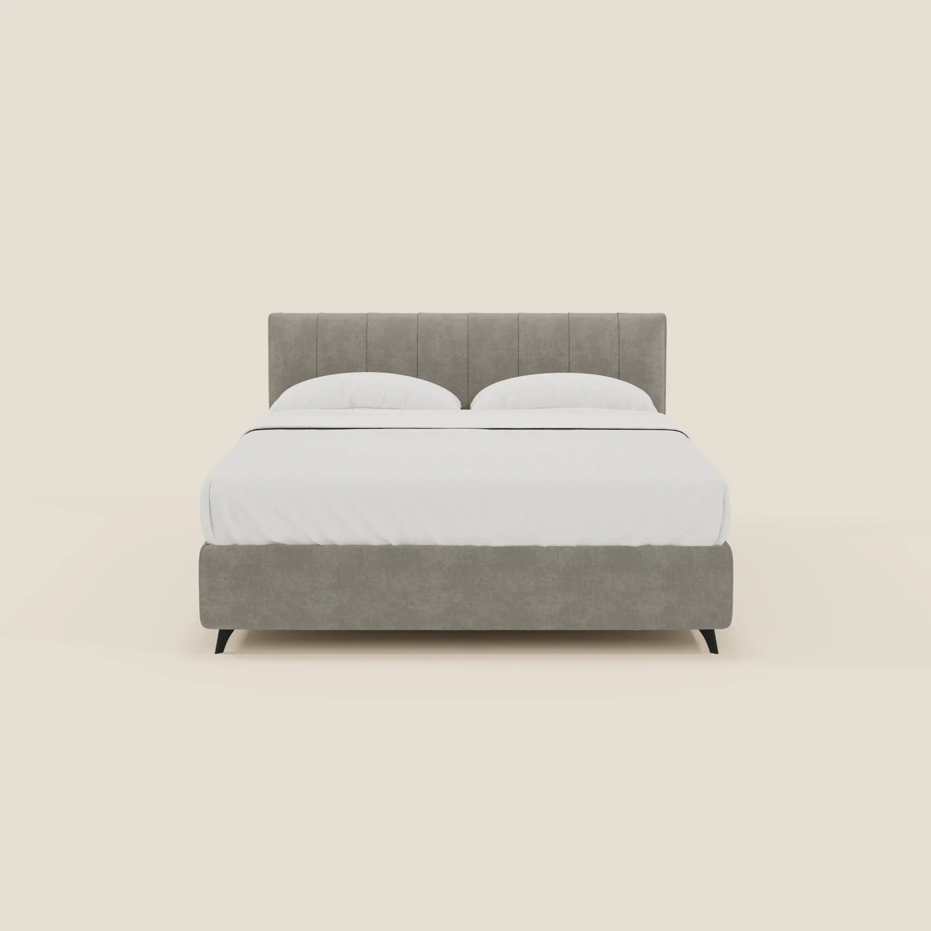 Il letto contenitore Bogart Edizione Grande Fratello di Letti.store ha un rivestimento sfoderabile e antimacchia in tessuto T22 grigio chiaro, cuciture verticali sulla testata e sulla base imbottite, gambe corte nere ed è abbinato a una biancheria da letto bianca e due cuscini.