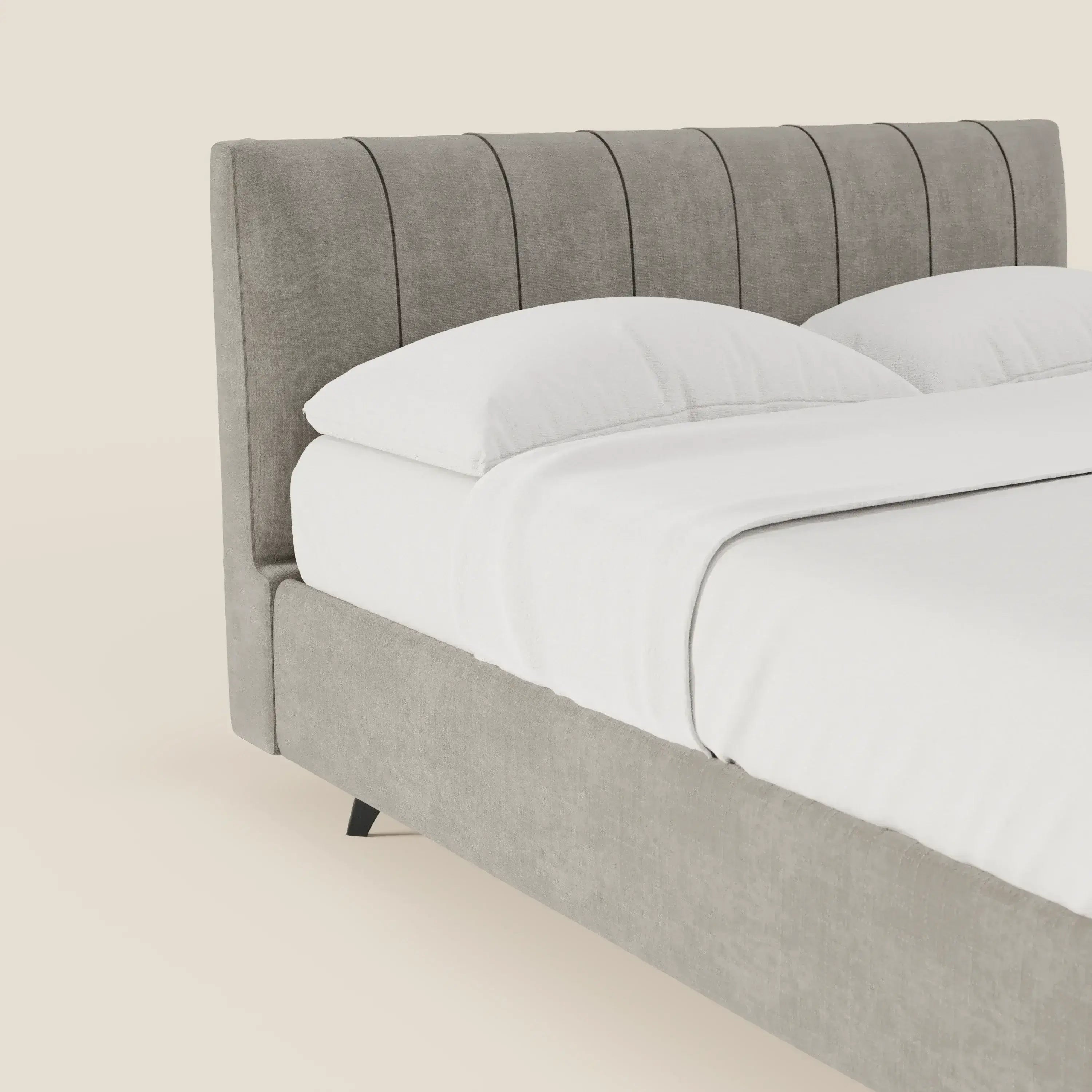 Primo piano del letto contenitore Bogart Edizione Grande Fratello di Letti.store, caratterizzato da un'alta testata imbottita e sfoderabile in tessuto antimacchia T22 grigio con cuciture verticali. Il letto è realizzato con cura e spicca su uno sfondo beige crema.