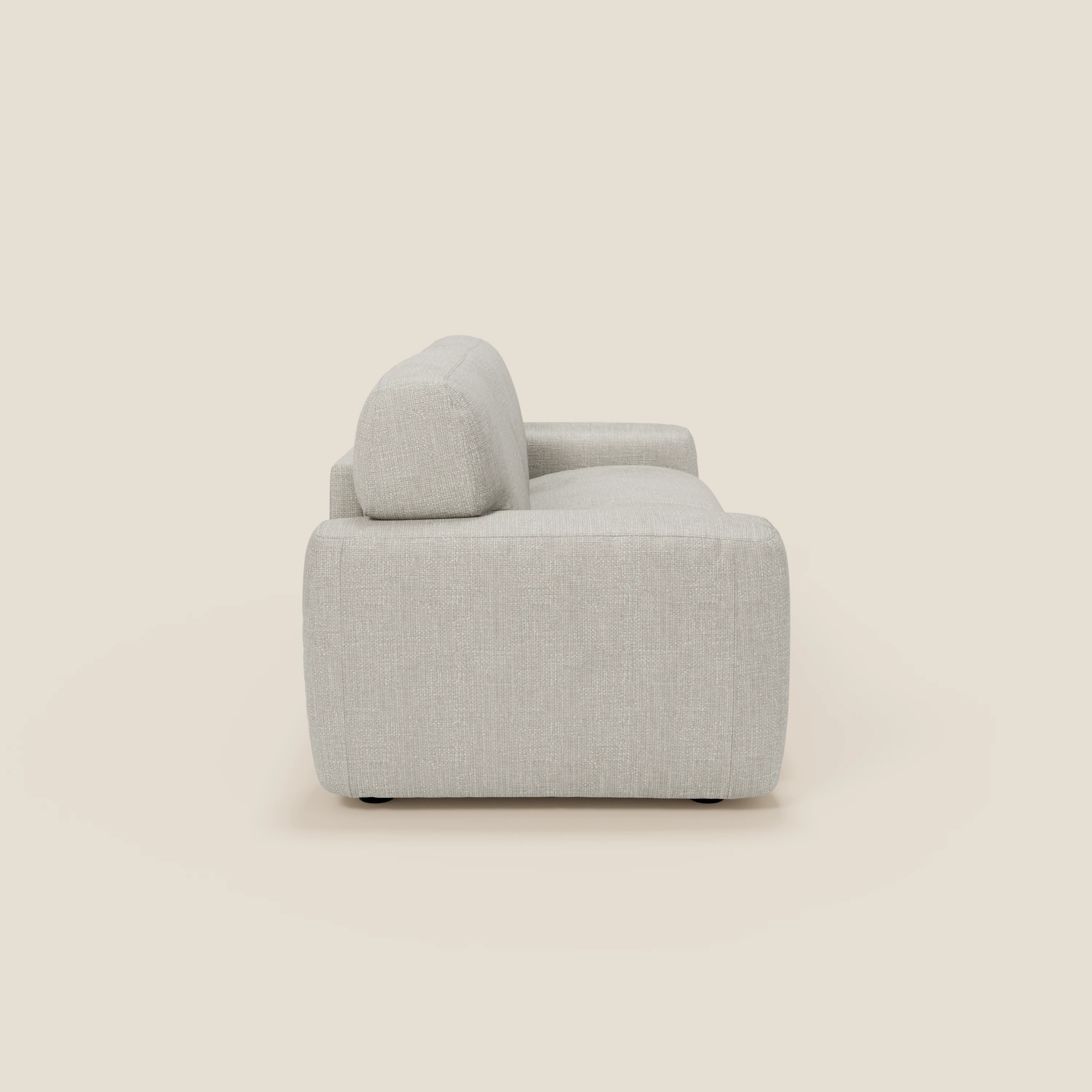 Una vista laterale di Cloud Divano letto materasso H17 cm di Divani.Store mostra il suo moderno tessuto impermeabile grigio chiaro T06, i cuscini morbidi e gli spessi braccioli arrotondati, ideali per il comfort quotidiano in qualsiasi spazio contemporaneo. Su uno sfondo beige semplice.