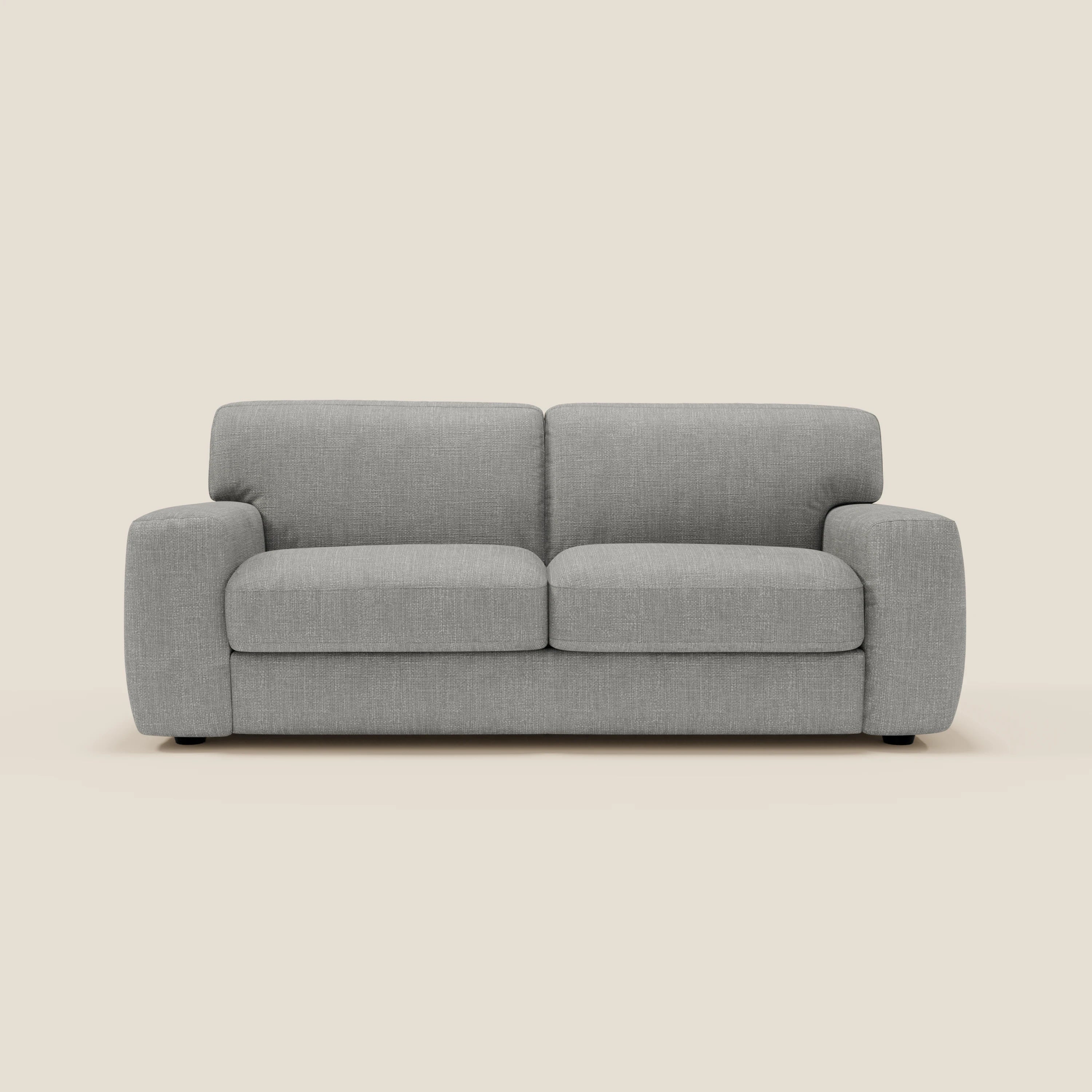 Un moderno Divani.Store Cloud Divano letto in tessuto impermeabile T06 grigio chiaro, con cuscini in feltro e braccioli arrotondati, si staglia su uno sfondo color crema. Questo divano minimalista a due o tre posti è caratterizzato da discrete gambe nere.