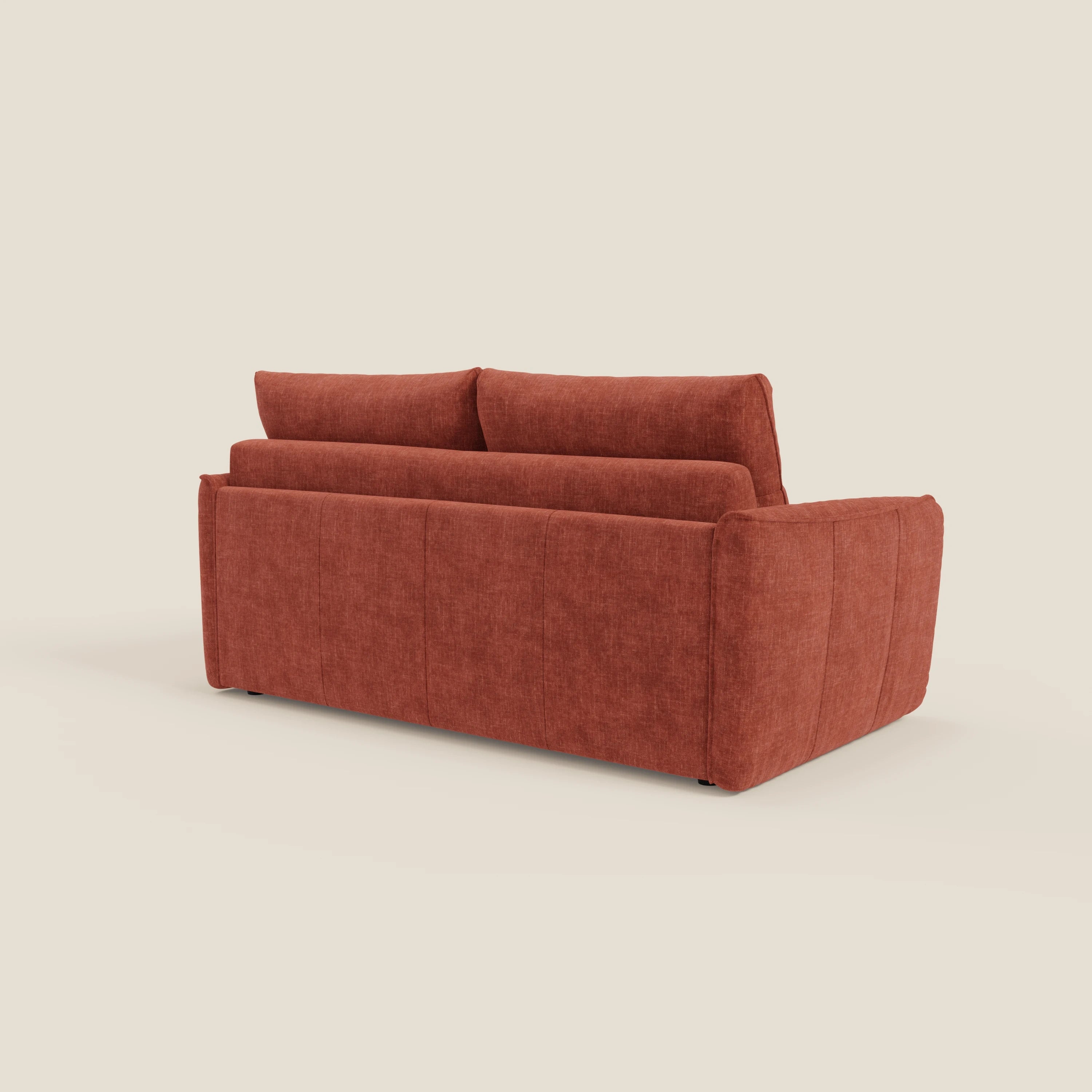 Elios Divano letto di Divani.Store è caratterizzato da ampi braccioli, cuscini di schienale e un design squadrato in tessuto ruggine T24 antimacchia. Visto di schiena e di lato, spicca su uno sfondo color crema chiaro.