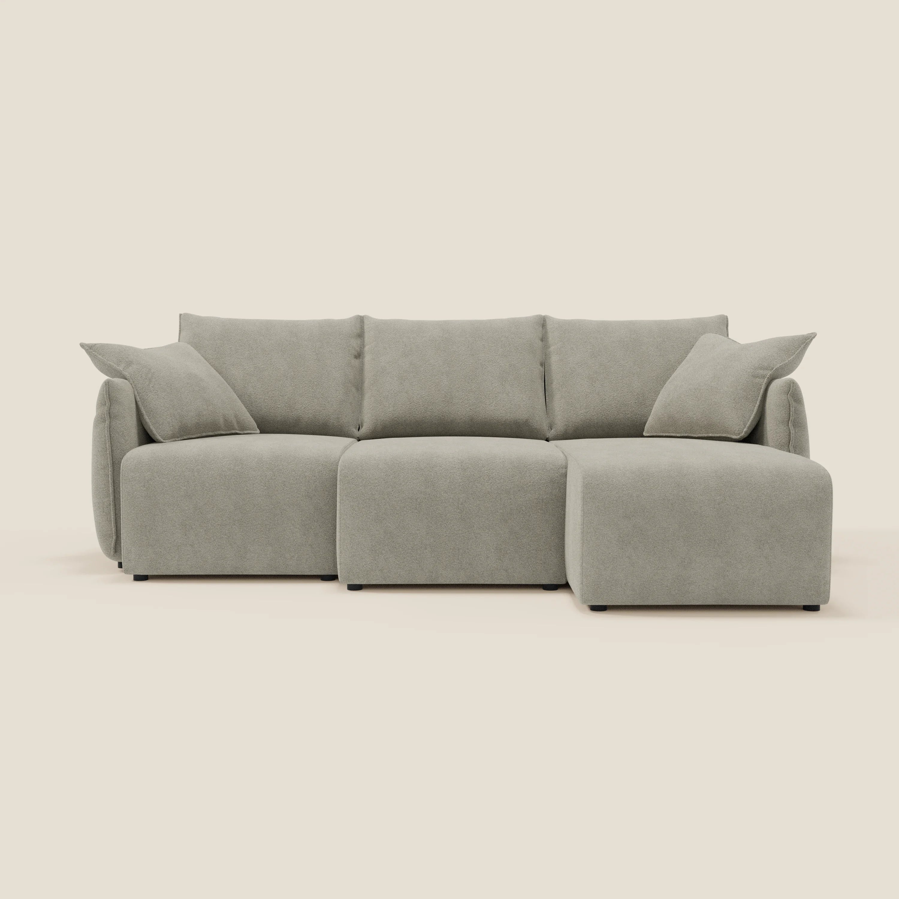 Il divano angolare reversibile Flexar di Divani.Store è caratterizzato da sedute allungabili in morbido bouclé impermeabile beige T07 e comprende due cuscini coordinati, il tutto su uno sfondo bianco sporco.