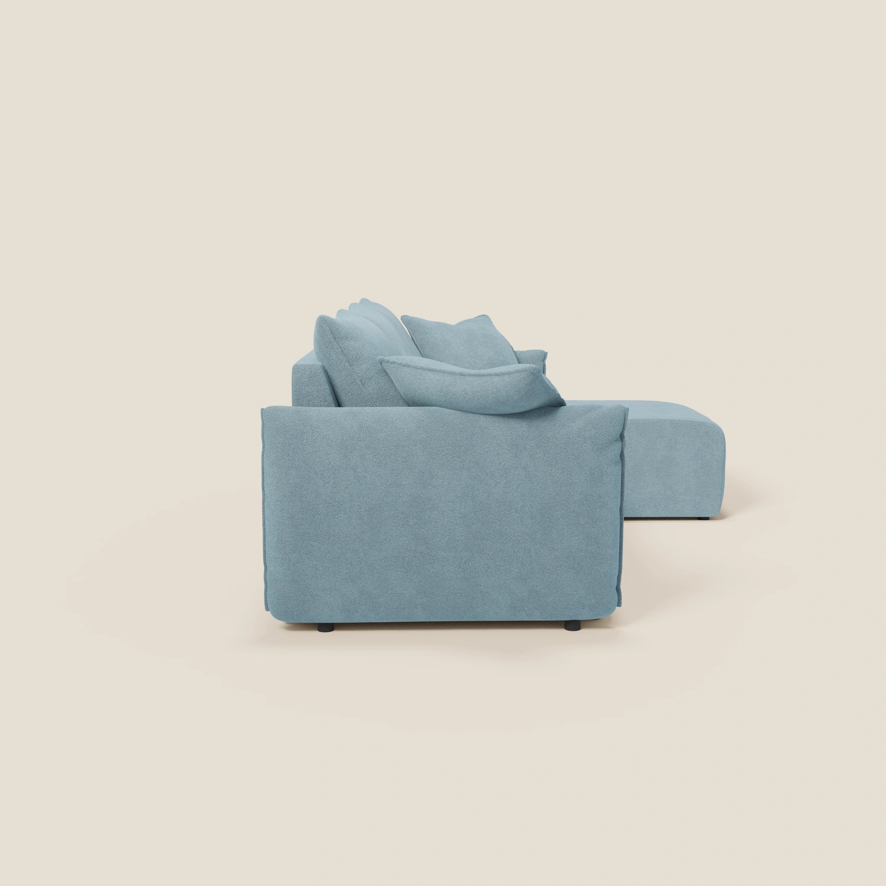 Il Divano angolare reversibile Flexar di Divani.Store, presentato lateralmente su sfondo crema, è caratterizzato da sedute allungabili, rivestimento impermeabile in bouclé T07 carta da zucchero e linee moderne e pulite con braccioli ampi e bassi.