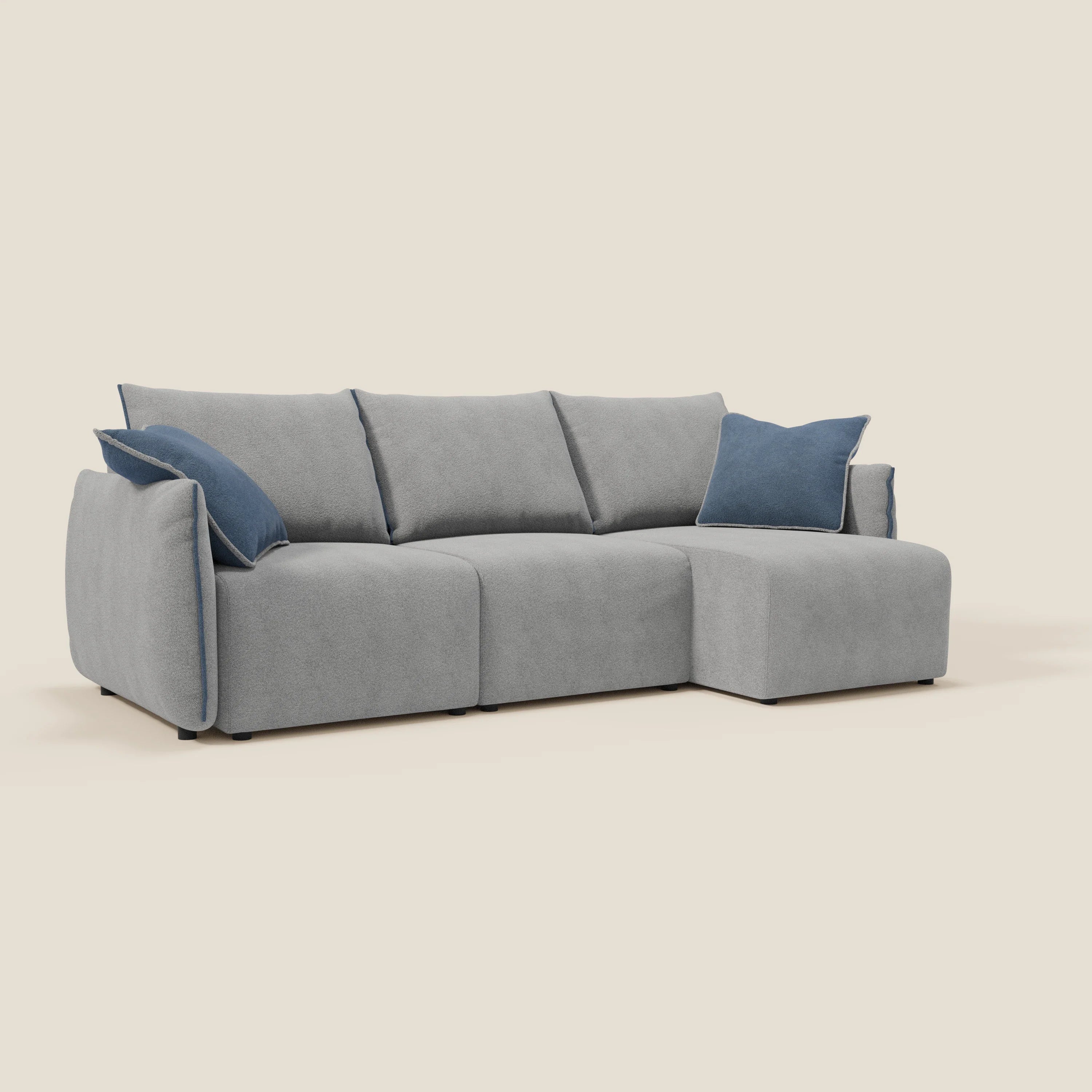 Il Flexar Divano angolare reversibile di Divani.Store è caratterizzato da un bouclé impermeabile grigio-blu, tre cuscini di seduta e di schienale, due cuscini blu scuro e sedute allungabili. Il tutto su uno sfondo beige chiaro.