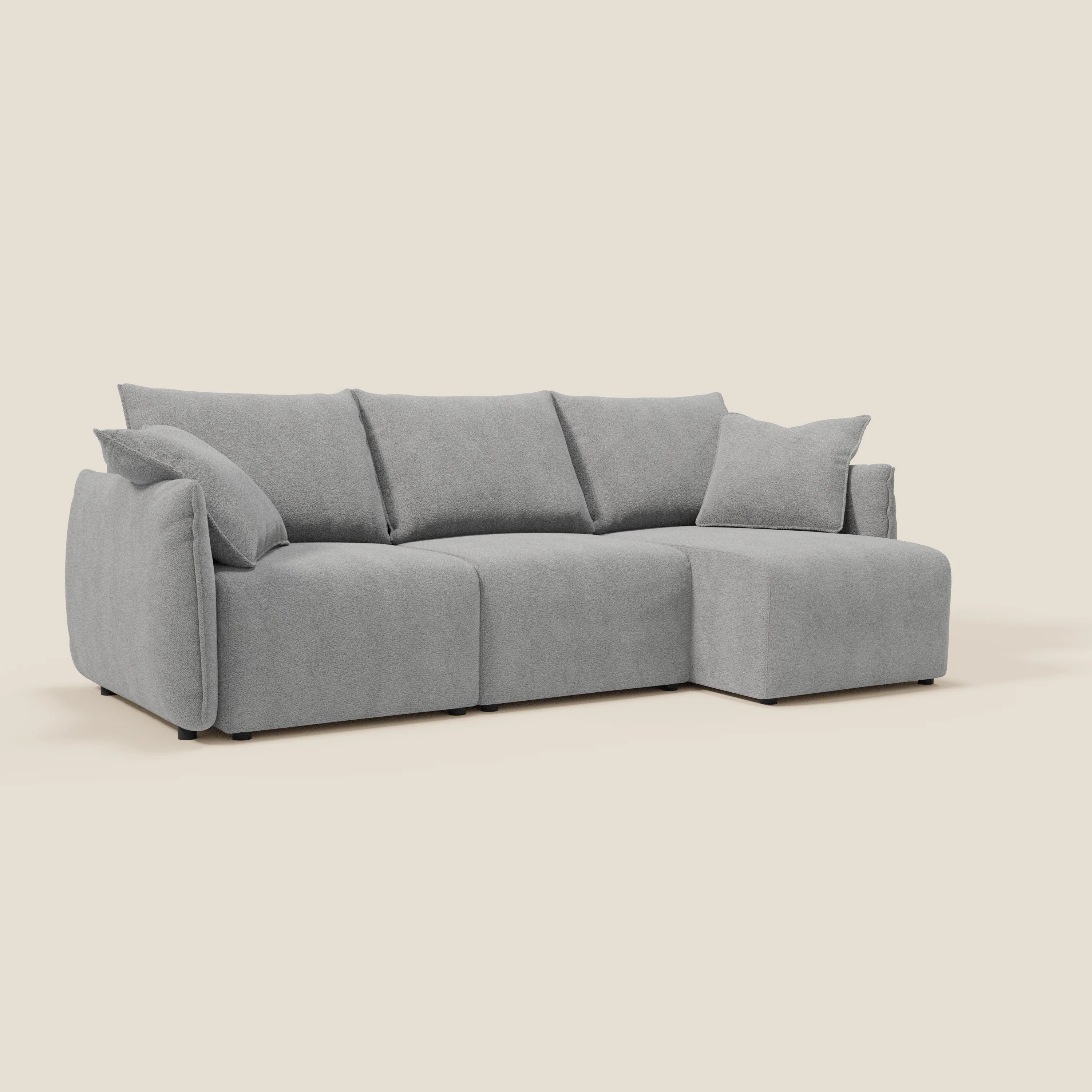 Il Flexar Divano angolare reversibile con sedute allungabili in bouclé morbido impermeabile T07 grigio di Divani.Store è caratterizzato da un design modulare grigio chiaro, cuscini morbidi, linee pulite e un cuscino coordinato su uno sfondo bianco sporco.