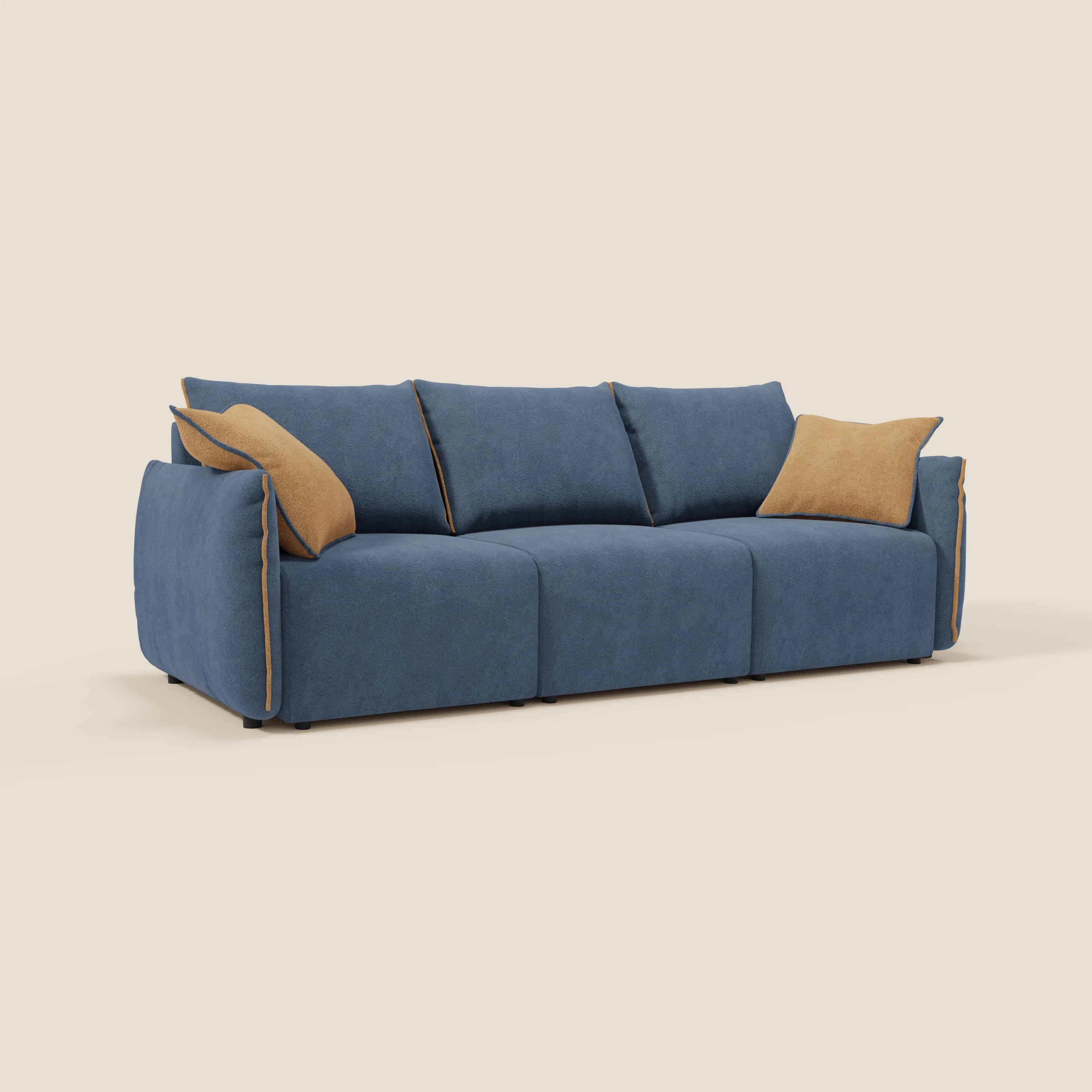 Il divano Flexar con 3 sedute allungabili di Divani.Store è caratterizzato da un'imbottitura in bouclé impermeabile blu T07, da profili arancioni e da due cuscini di stoffa color tan. I bordi arrotondati e i piedini neri corti completano il look moderno su uno sfondo beige chiaro.